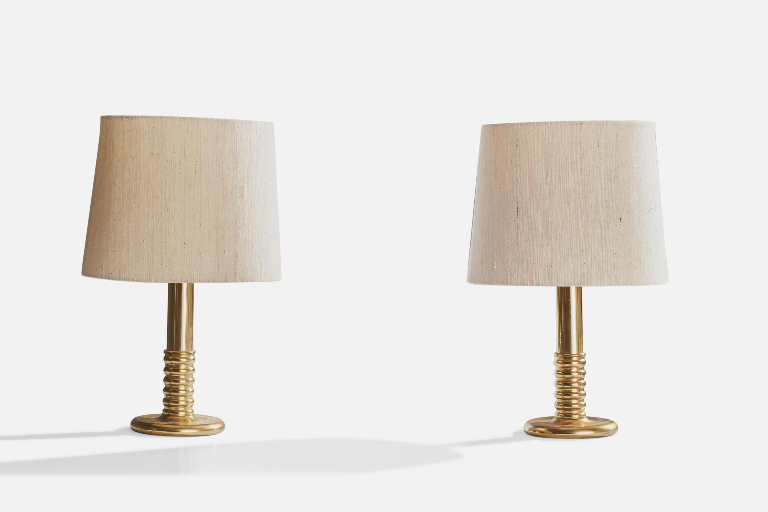 A pair of brass and off-white fabric table lamps produced by Ivars, Sweden, c. 1970s.

Overall Dimensions (inches): 14.25”  H x 7”  D
Stated dimensions include shade.
Bulb Specifications: E-26 Bulb
Number of Sockets: 2
All lighting will be converted