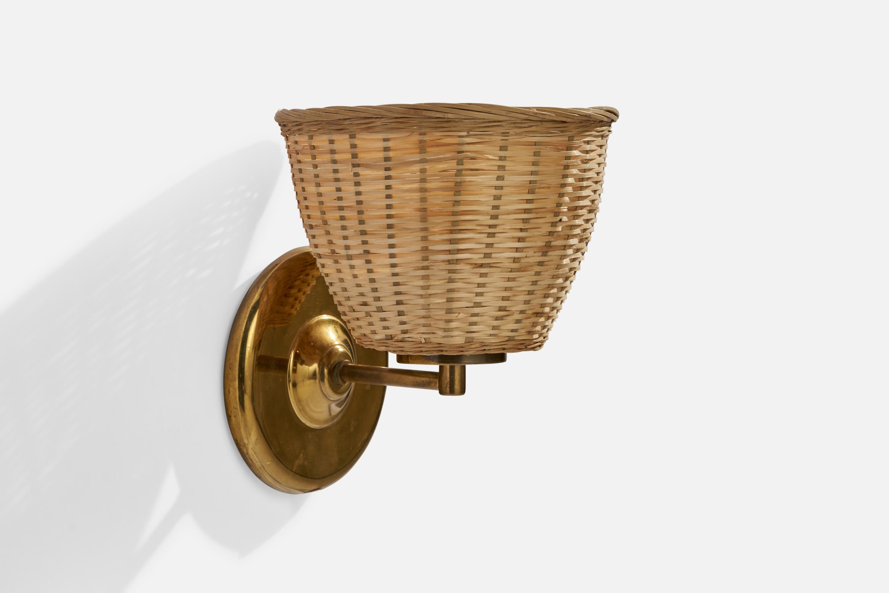 A brass and rattan wall light designed and produced by Ivars, Sweden, c. 1960s.

Overall Dimensions (inches): 8” H x 7”  W x 7” D
Back Plate Dimensions (inches): 5.25” H x 5.25” W x .75 D
Bulb Specifications: E-26 Bulb
Number of Sockets: 1
All