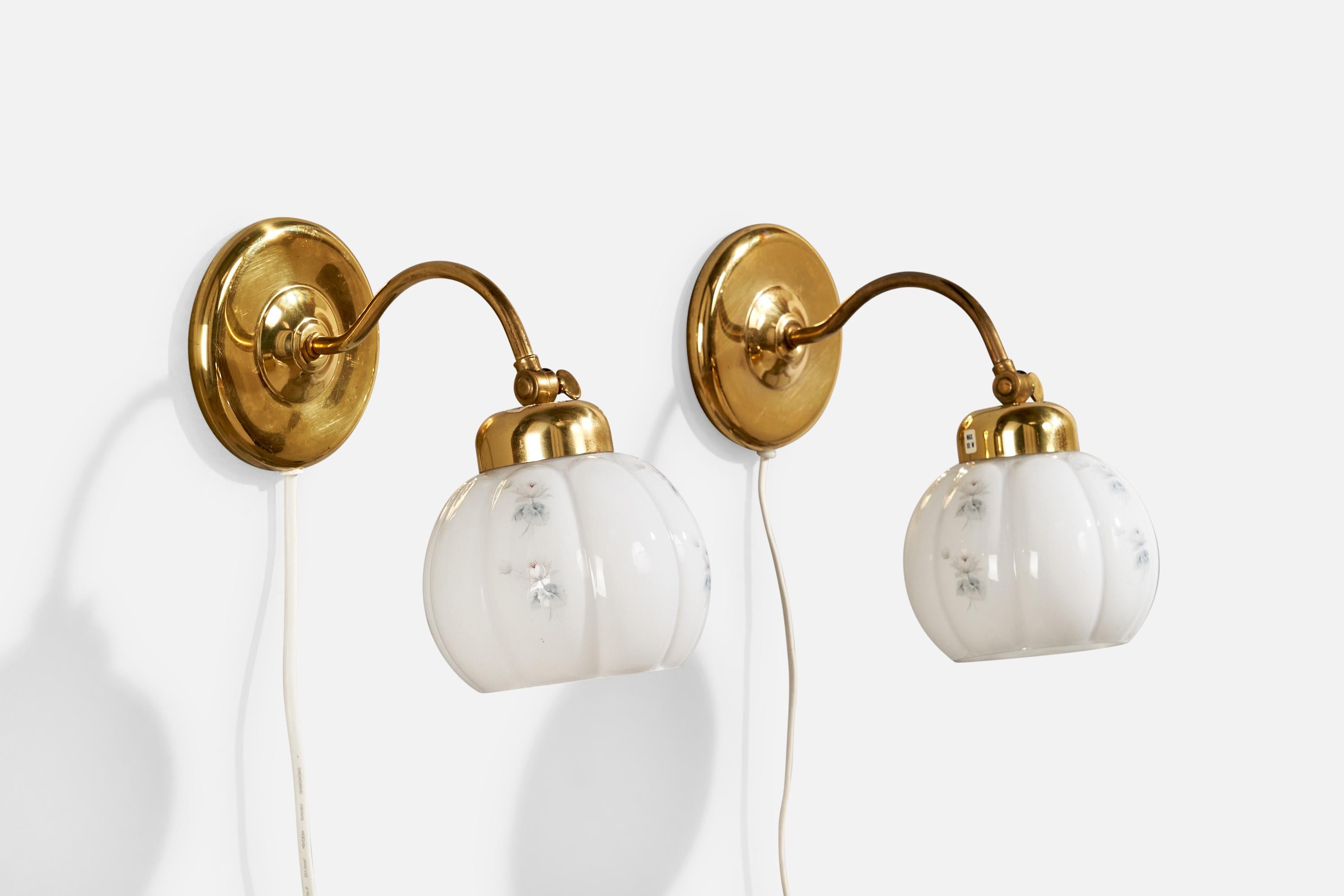 A pair of brass and floral-printed white opaline glass wall lights designed and produced in Sweden, c. 1960s.

Overall Dimensions (inches):  9” H x  5.75” W x  9.25“ D

Back Plate Dimensions (Inches):  5” H x 5” W x 1” D

Bulb Specifications: