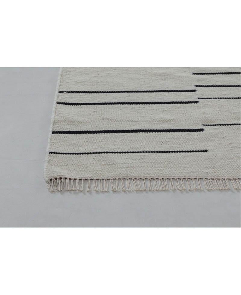 Elevate your space with timeless sophistication through our Ivory Elegance: 100% Wool Dhurrie Stripe Rug. Crafted to perfection, this exquisite rug effortlessly combines classic design with luxurious materials to bring a touch of refined style to