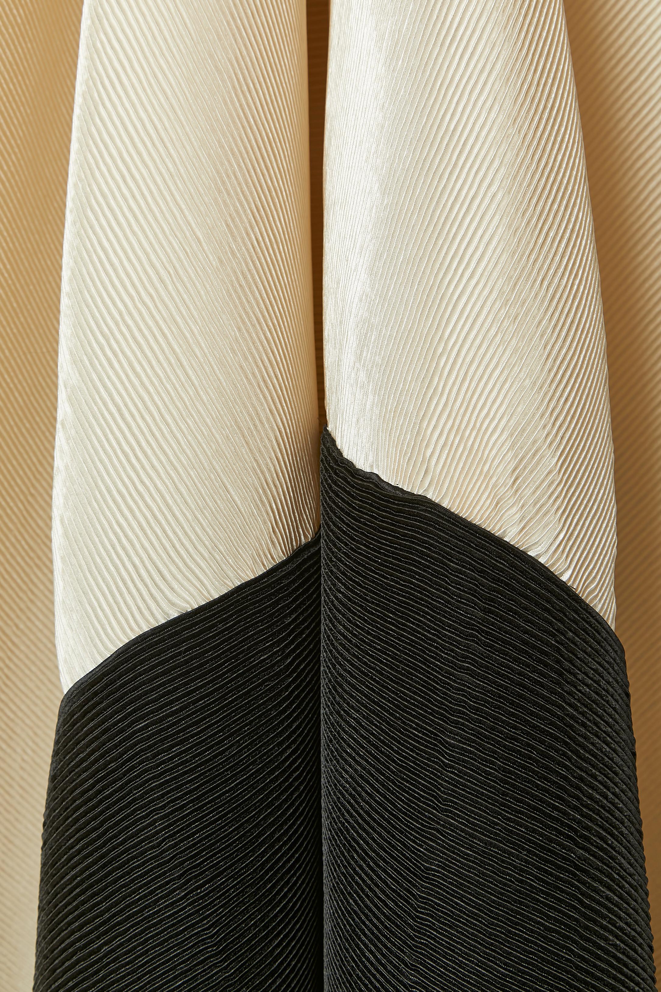 Robe de soirée bustier plissée ivoire et noire avec traîne.  Composition du tissu principal : 100% polyester. Composition du tissu intérieur : 55% coton, 45% rayonne. Composition des dernières touches : 100% soie. 
Bustier désossé à l'intérieur de