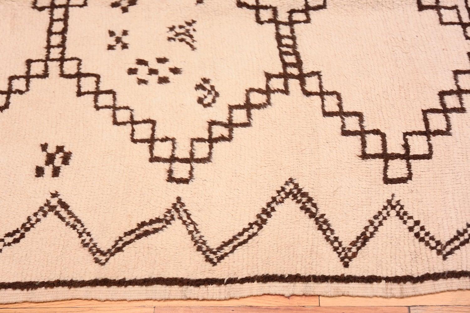 Vintage ivory and brown Moroccan rug, origin: Morocco, circa mid-20th century. Size: 4 ft 5 in x 7 ft (1.35 m x 2.13 m). 

Here is a unique and thought-provoking vintage carpet – a mid-century Moroccan rug, characterized by a beautiful and typical
