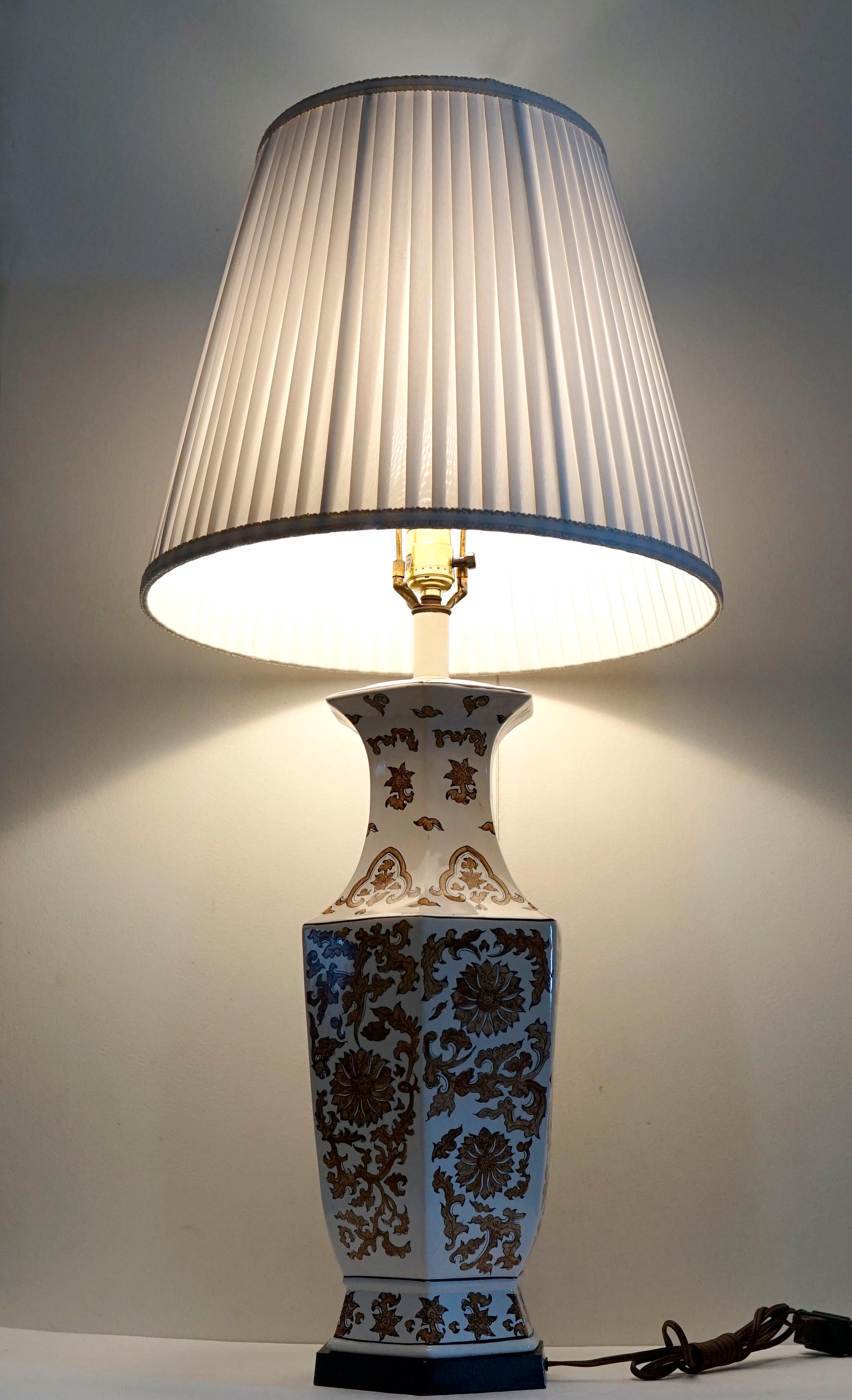 The hexagon shape and the elegant design of floral and botannical elements make this lamp a standout on a white background. The lamp is in beautiful condition without condition issues. The hexagon shape is architectural and the lamp makes a dramatic