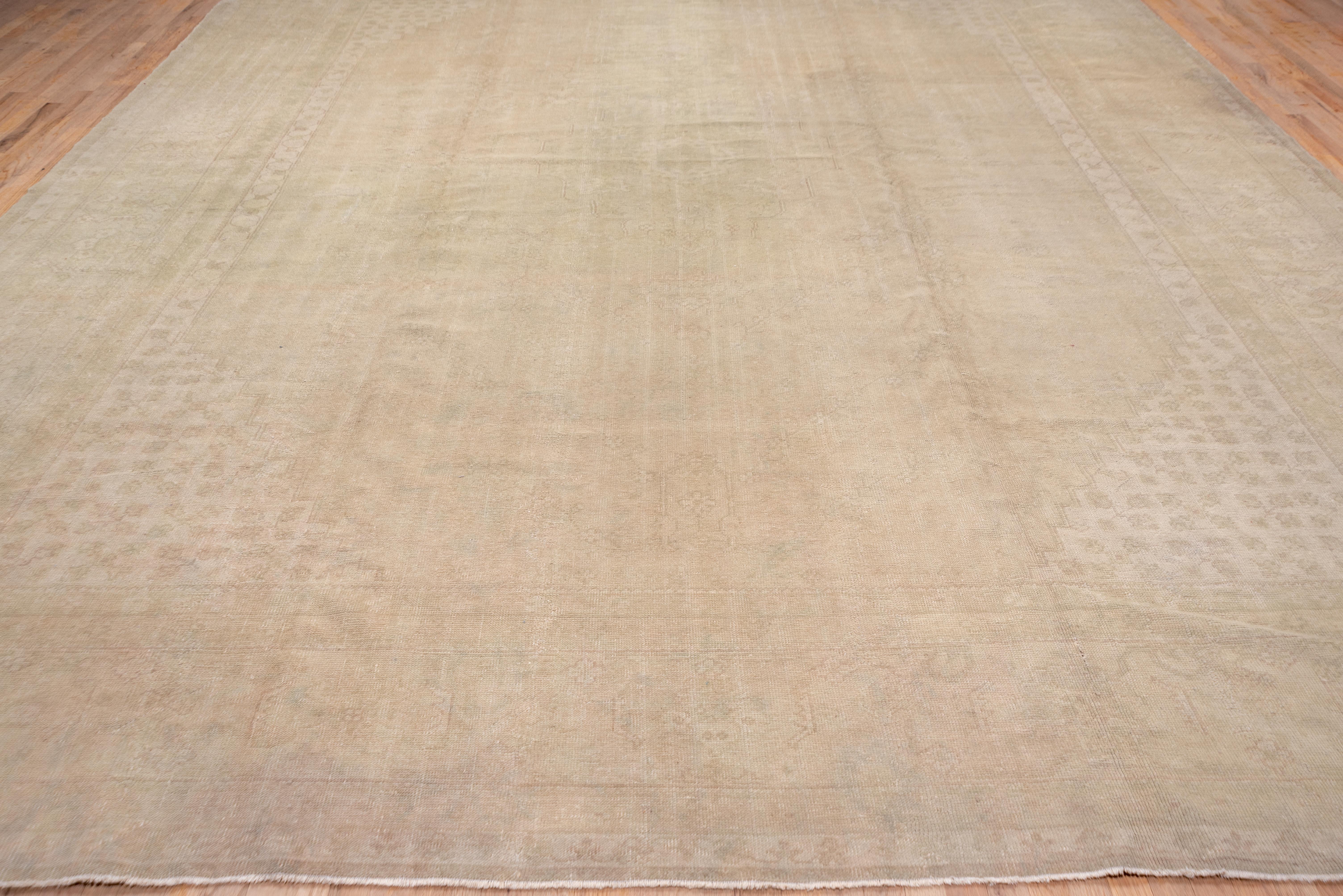 Dies ist ein tonal sehr gedämpfter westlicher türkischer Teppich in Creme-, Hellbeige- und hellsten Grüntönen. Auf einem cremefarbenen Feld zeigt das kartuschenförmige Feld ein Ton-in-Ton-Medaillon. Das Muster ist im Allgemeinen gegenüber dem