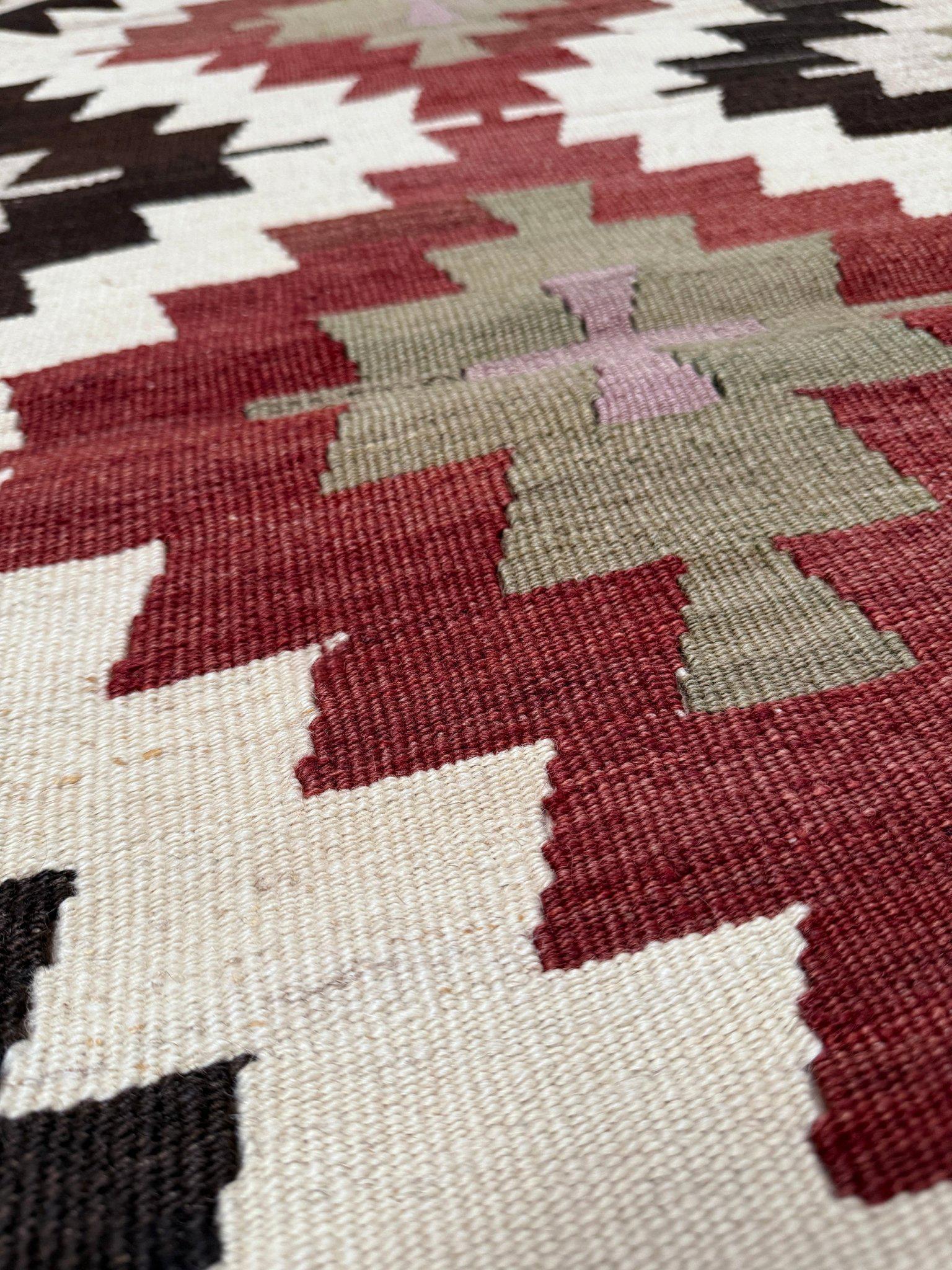 Tessuto a mano nella regione di Mut, nel sud della Turchia, questo kilim di metà secolo presenta un audace layout geometrico di ispirazione Navajo con medaglioni a diamante impilati e motivi a gradini. Il design è realizzato in una tavolozza calda e