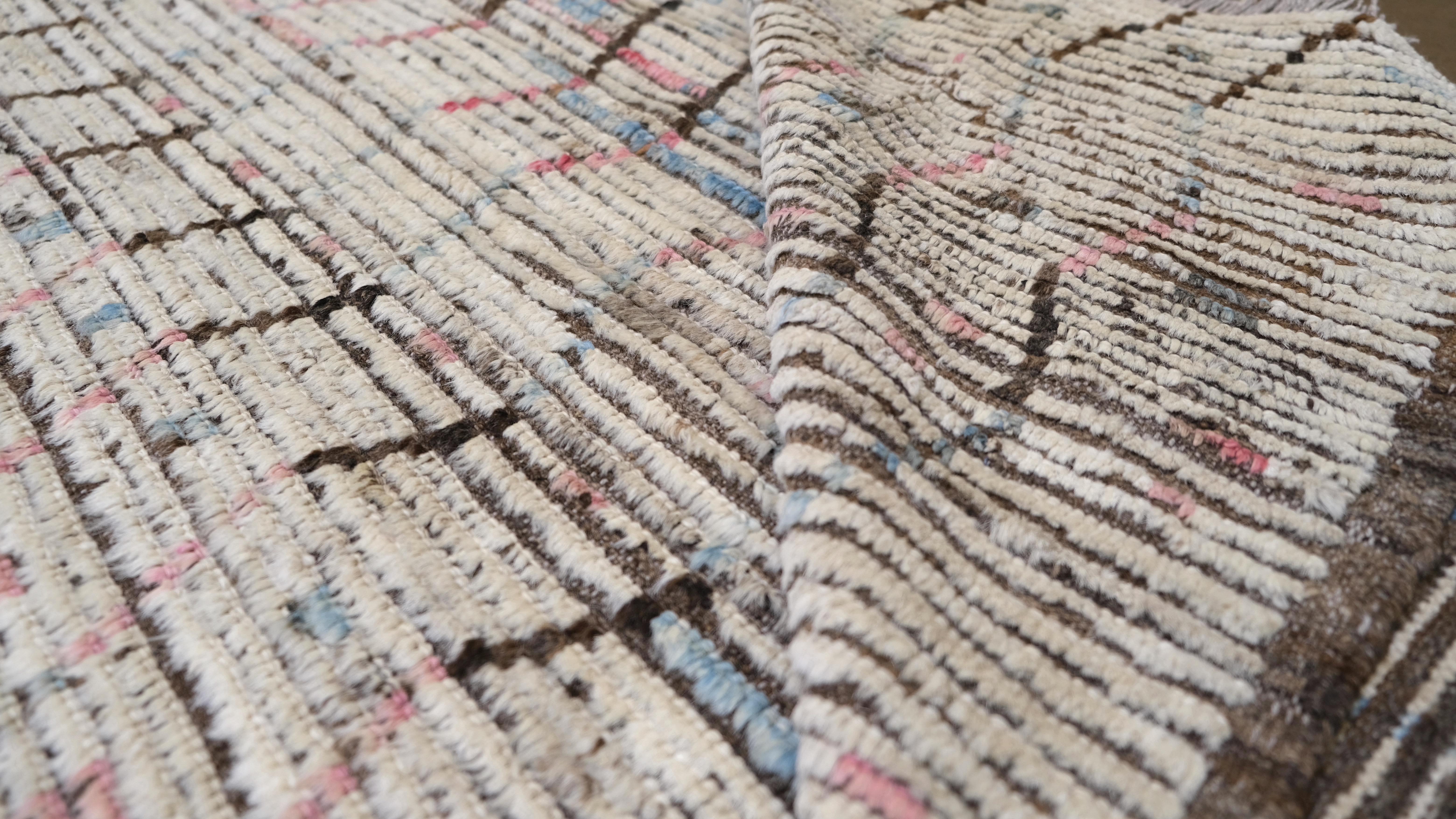 Plongez votre espace dans l'élégance discrète de cette  tapis en laine noué à la main, présentant un motif linéaire abstrait complexe. Tissé avec précision par des artisans qualifiés, ce tapis présente une douce palette d'ivoire, de beige, de bleu,