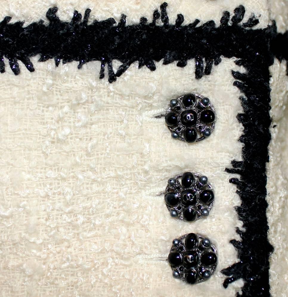 A true CHANEL signature item in the so famous black and white that will last you for many years
Faux wrap skirt with Chanel CC jewelry buttons
Completely lined with finest stretchy silk
Beautiful CHANEL tweed boucle skirt
A true CHANEL signature