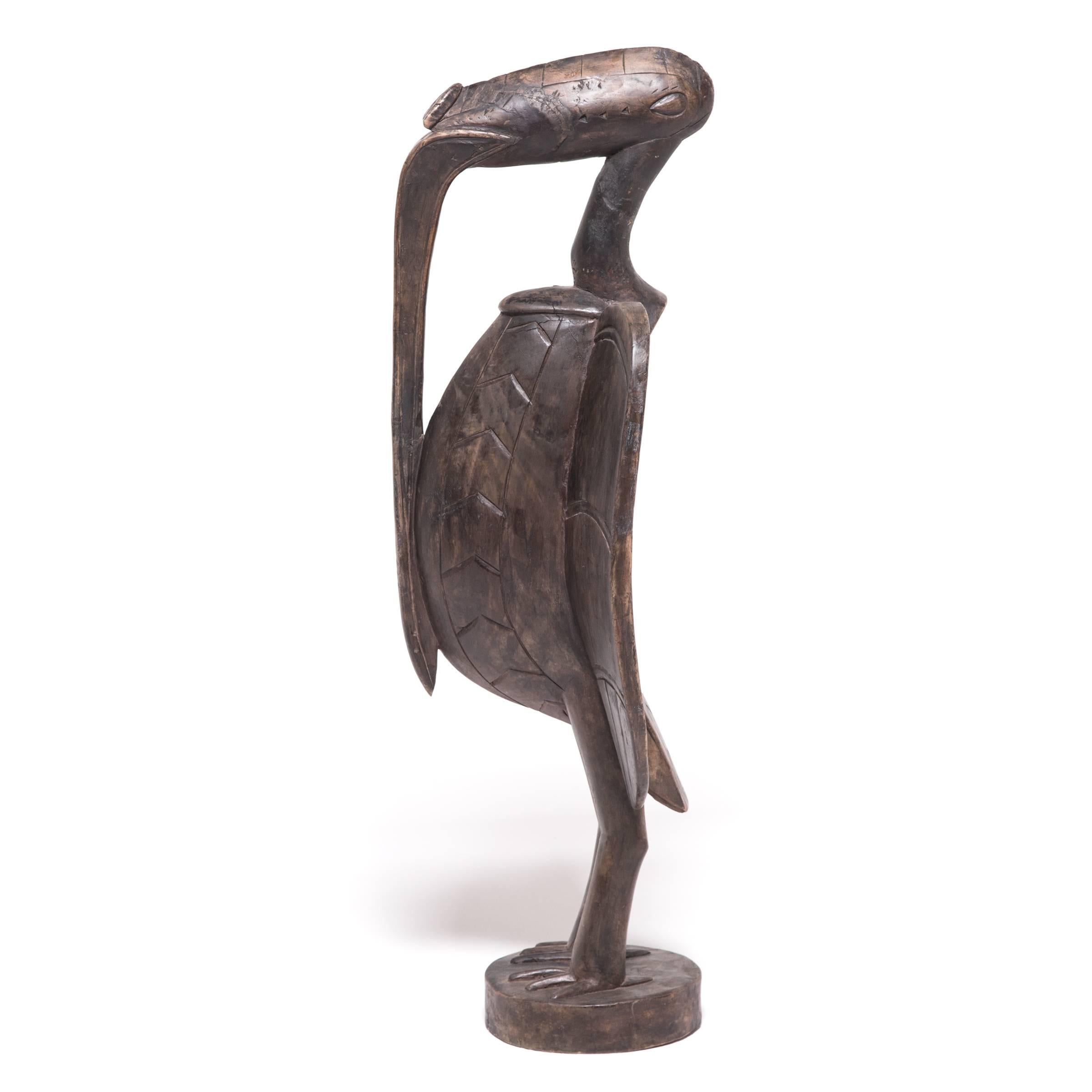This striking bird figure may have once been kept in a sacred grove, protecting the initiated male members of a Senufo society. Likely modeled after the yellow-casqued hornbill, this sculpture exaggerates the bird’s form with outstretched wings, a