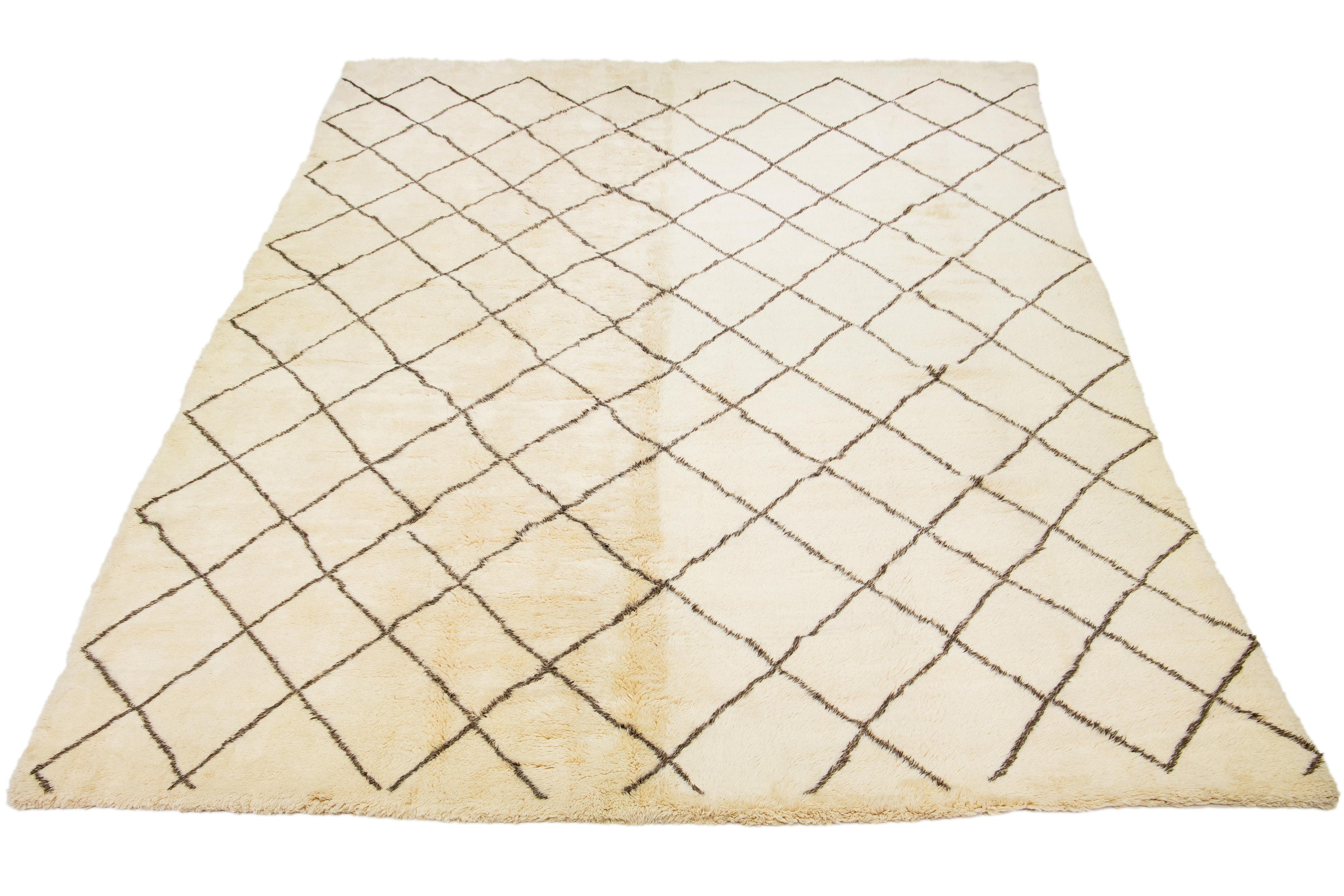 Ein atemberaubender, moderner Wollteppich im marokkanischen Stil, sorgfältig von Hand geknüpft mit einem beigen Grundton, der durch braune Akzente in einem fesselnden geometrischen Allover-Muster ergänzt wird.

Dieser Teppich misst 13'1'' x 20'.