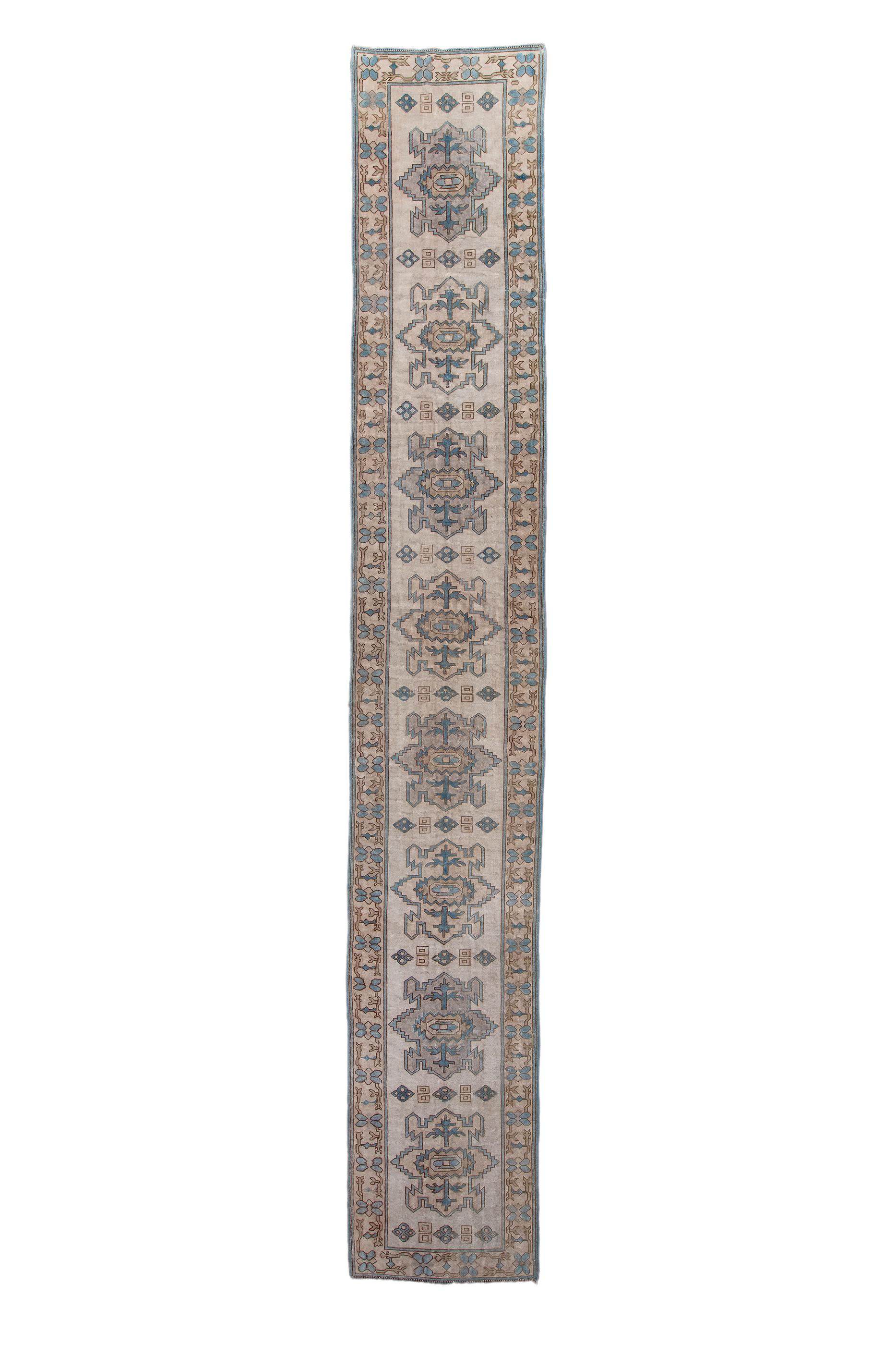 The ivory field displays eight reptilian medallions, all with flower and stem centres, and uniformly divided by short strings of squares and lozenges. Simple flower, straw ground narrow border. Coarse weave, good condition.

Rug Size
2'10x18'1