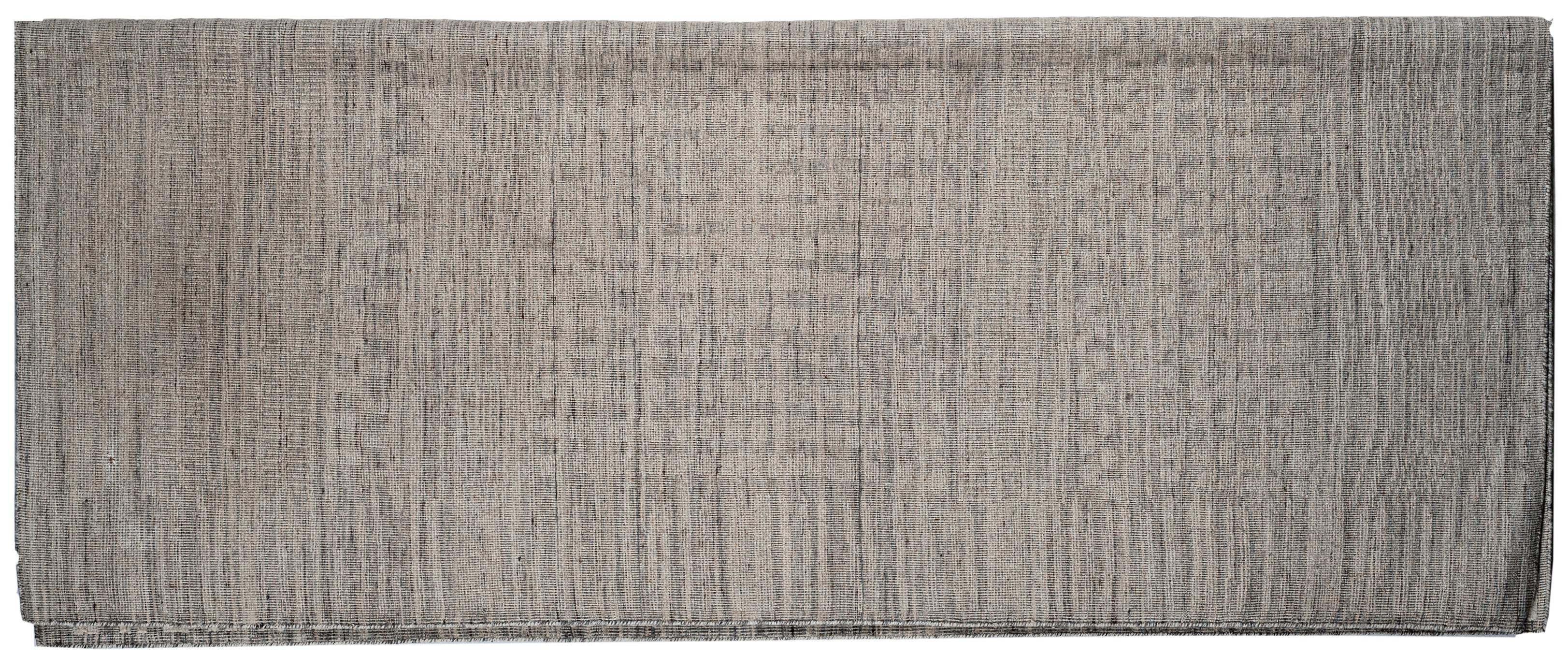 L'utilisation créative de fibres de laine coupées et bouclées confère à ce tapis d'extérieur un aspect distinct et un toucher séduisant. Fabriqué à la main en Inde à l'aide de matériaux et de teintures naturels.