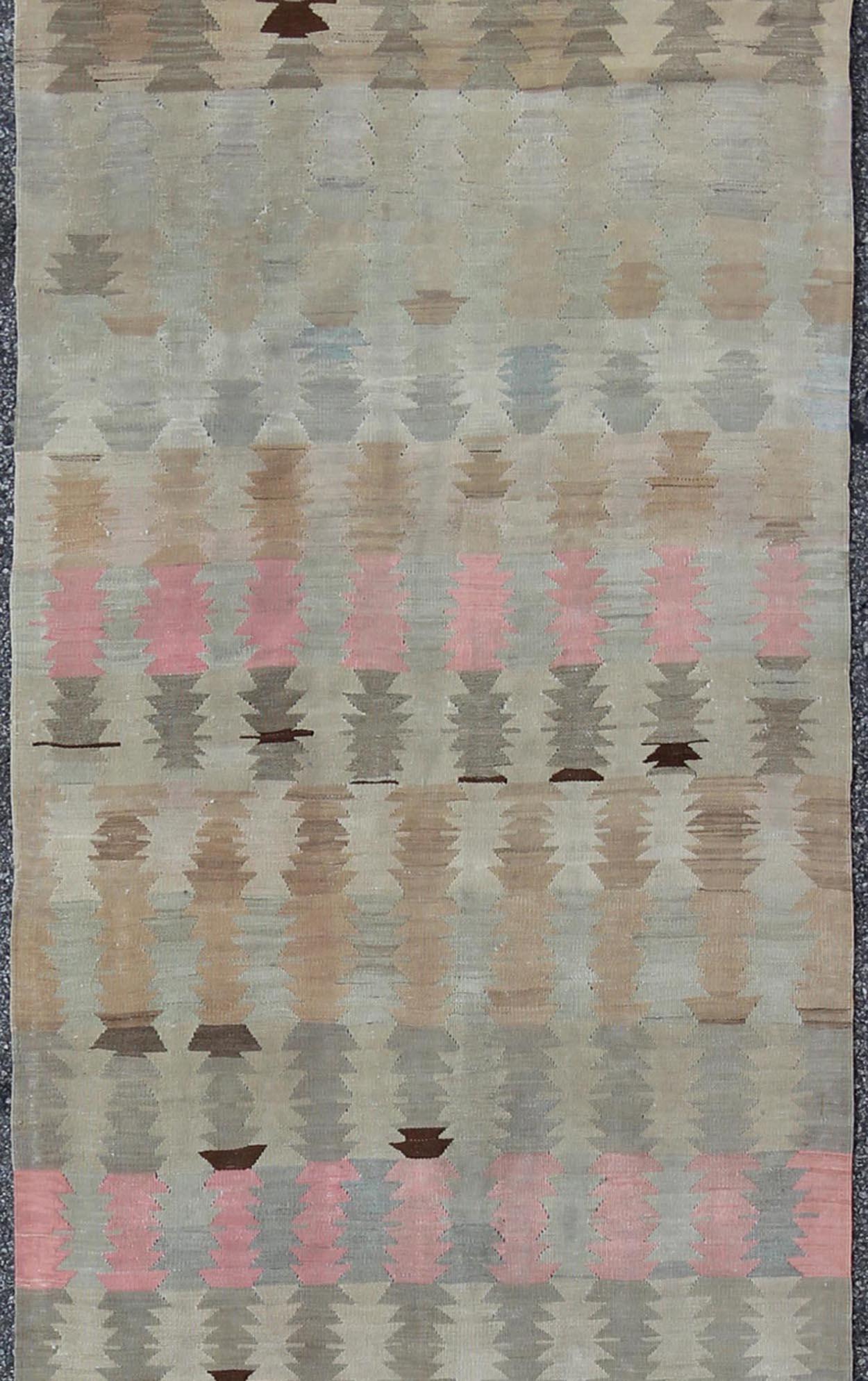 Geometric design flat-weave Kilim runner from Turkey in neutral, muted colors, rug/EN-165685, country of origin / type: Turkey / Kilim, circa 1950

Featuring a beautiful geometric design rendered in muted tones, this unique midcentury Kilim runner