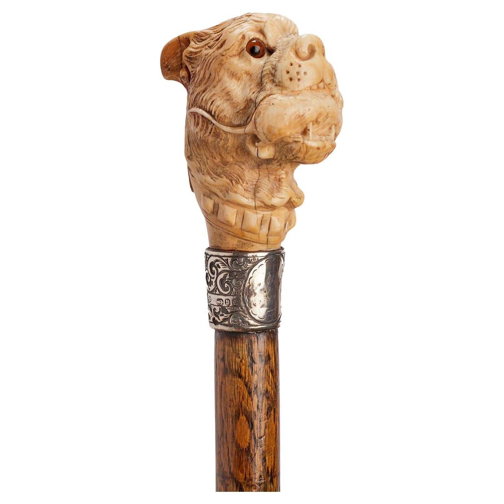 Ivory handle walking stick depicting a dog’s head holding a mouse, England 1890.
