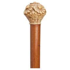 Bastón con mango de marfil que representa un jarrón con margaritas, Francia 1915.