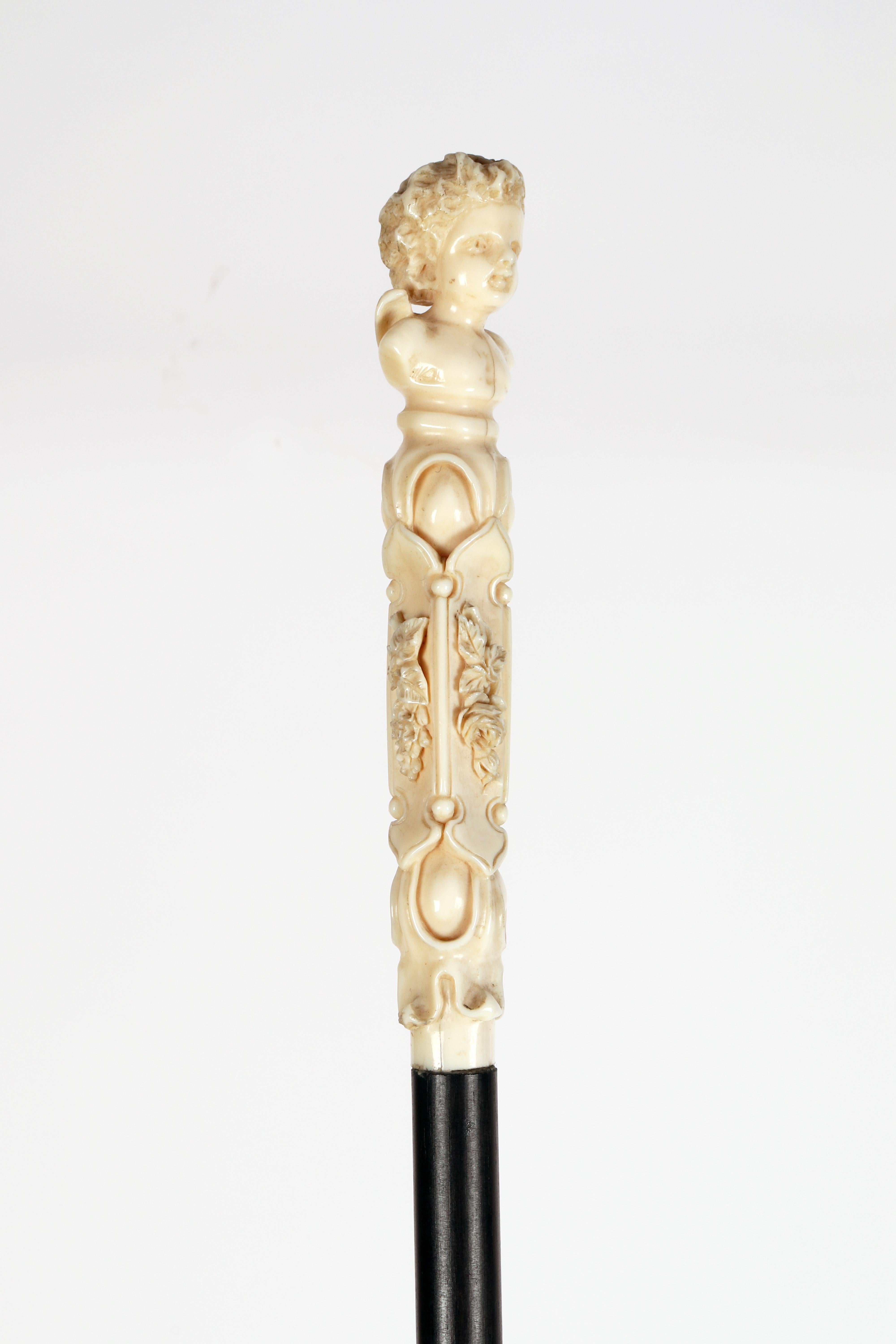 Bastone da passeggio: pomello in avorio intagliato raffigurante il busto di un angelo con fiori. Fusto in legno di ebano. Punta di avorio. Dieppe, Francia, 1850 circa. (SOLO PER L'UE)