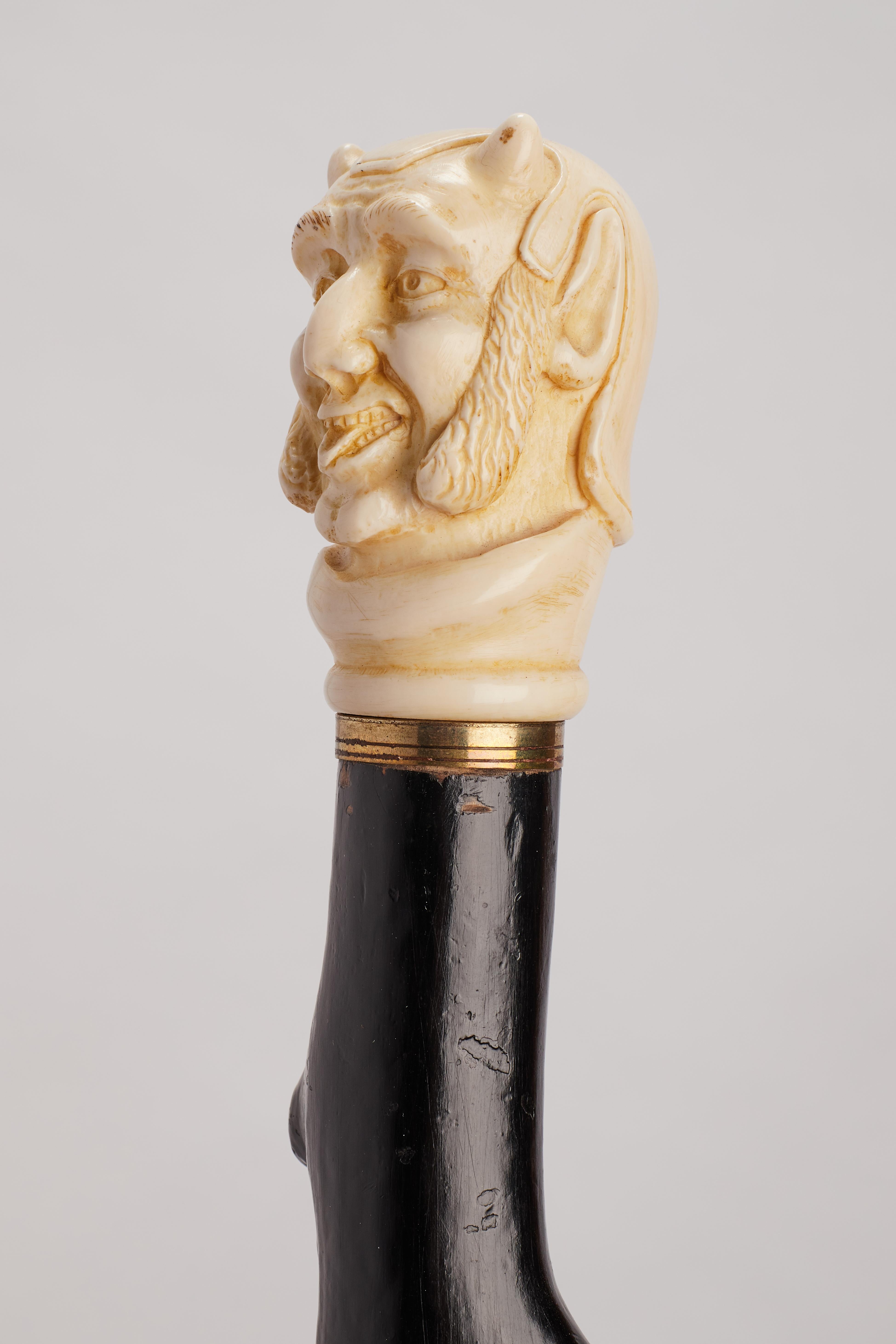 Metal Ivory handle walking stick depicting Mephistopheles face, England 1870. For Sale