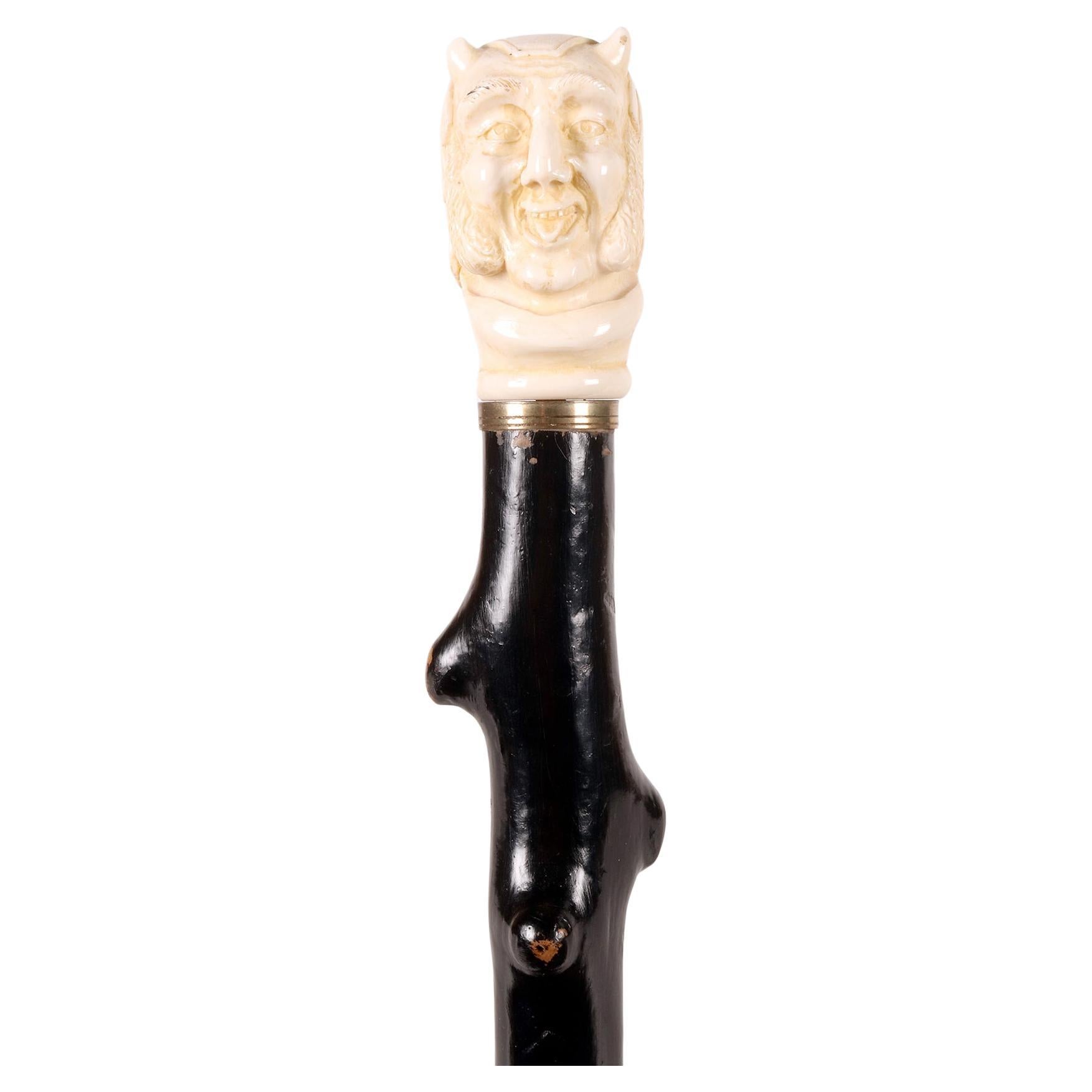Ivory handle walking stick depicting Mephistopheles face, England 1870.