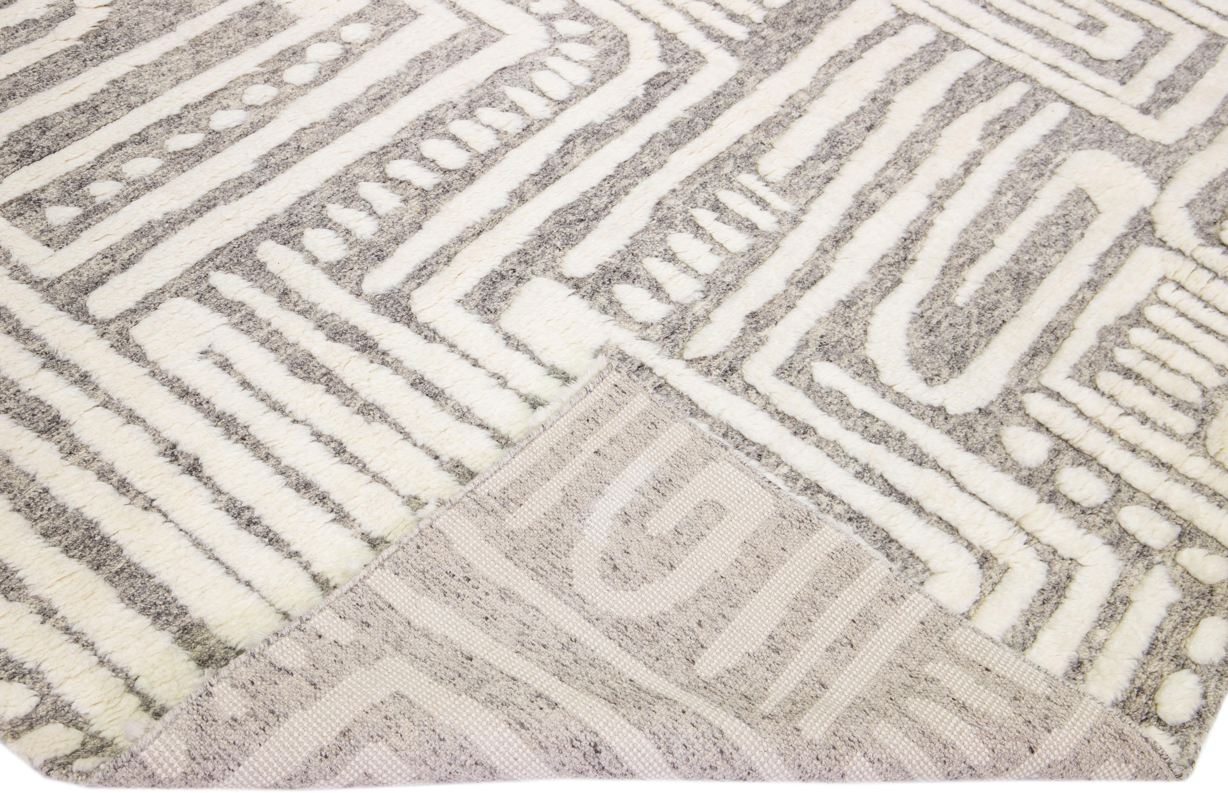 Beautiful modern Moroccan style hand-knotted wool rug with a light gray color field and ivory accents in a gorgeous abstract high pile design.

This rug measures: 9'8