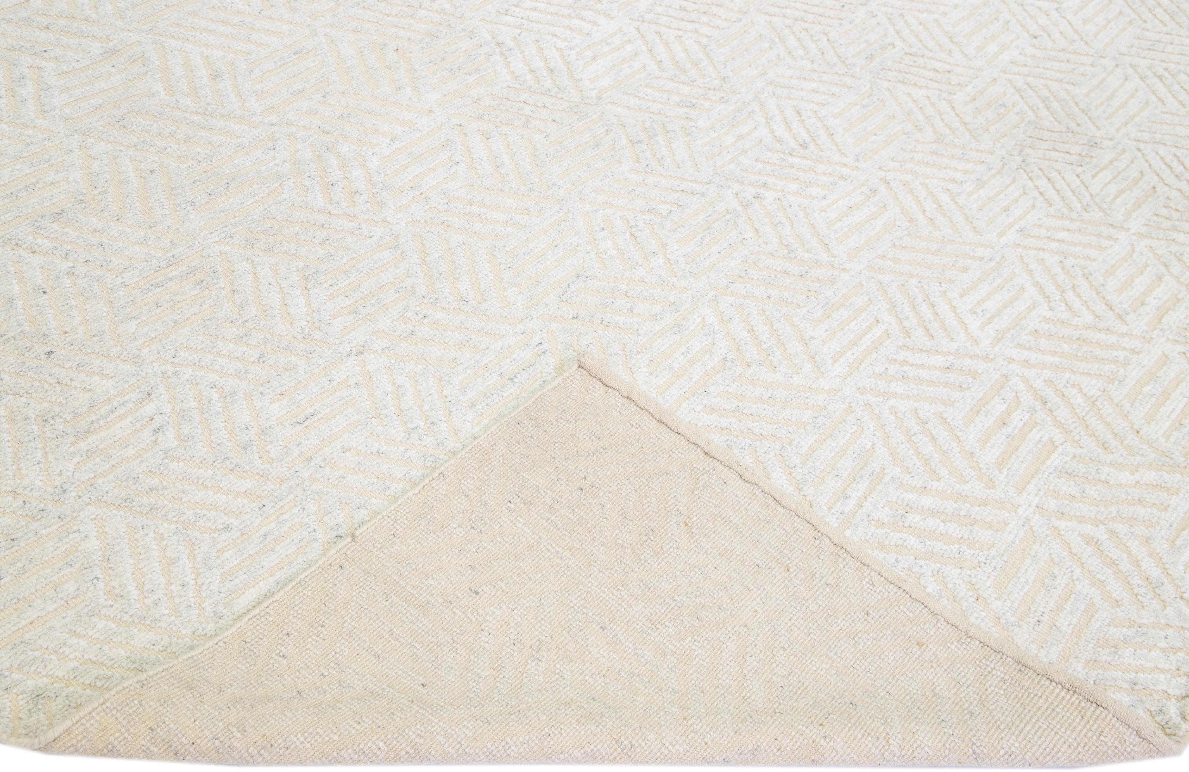 Beautiful modern Moroccan style hand-knotted wool rug with an antique white field. This piece has ivory in the all-over geometric abstract design.

This rug measures: 12'1