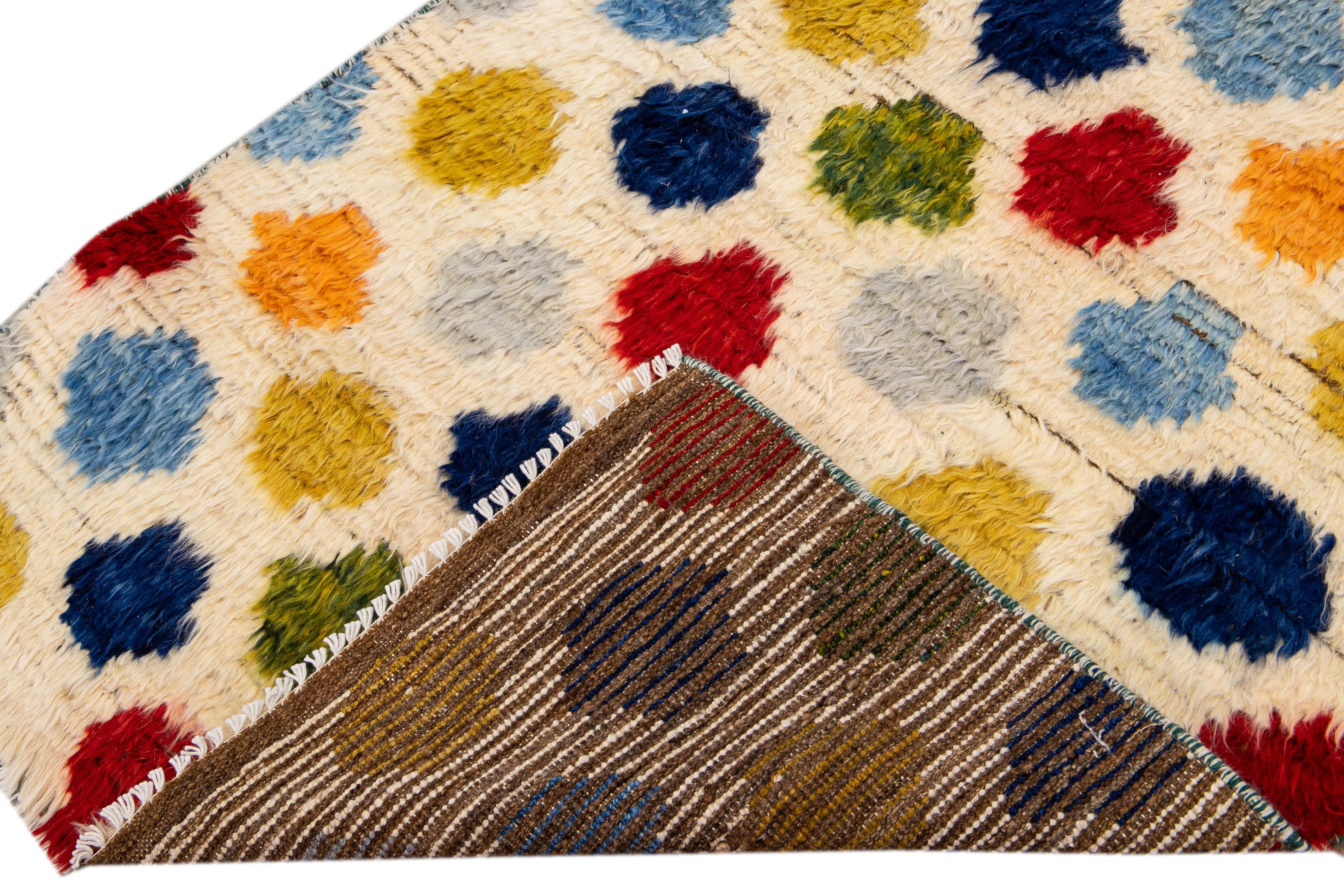 Beautiful Moroccan style handmade wool rug with an ivory field. This Modern rug has multicolor accents featuring a gorgeous all-over bohemian dots design.

This rug measures: 3'2