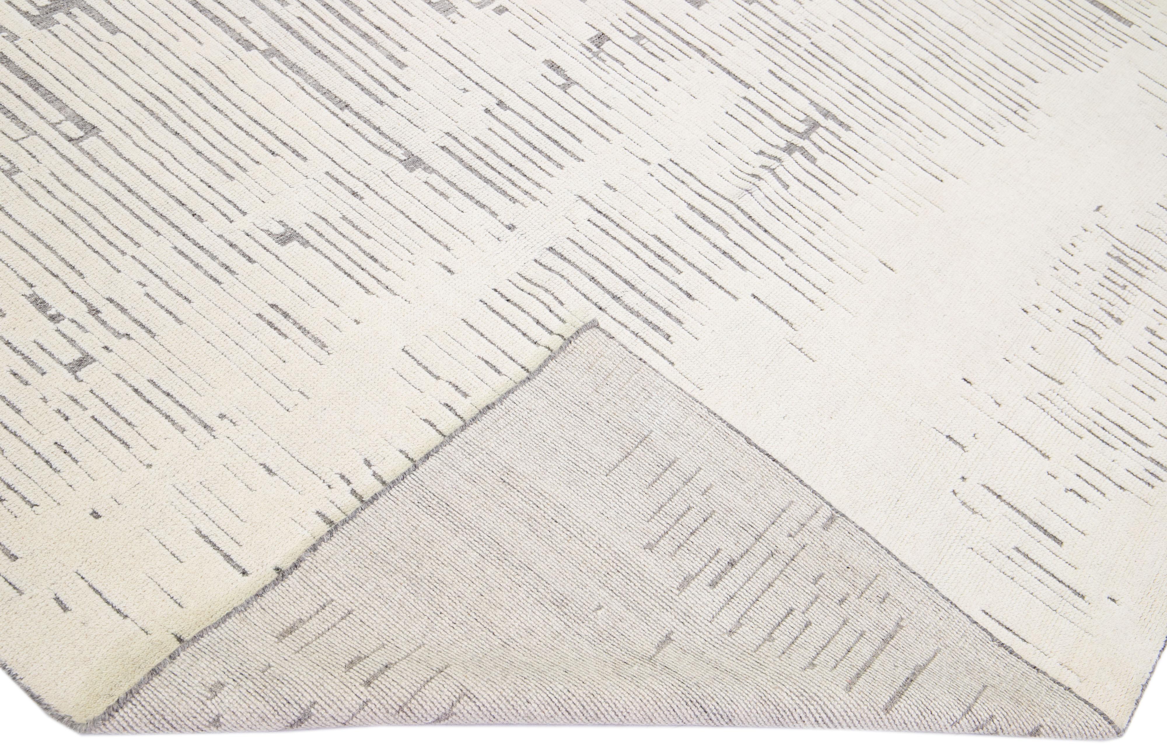Magnifique tapis moderne de style marocain en laine nouée à la main avec un champ gris clair et des accents ivoires dans un magnifique design géométrique abstrait à poils hauts.

Ce tapis mesure : 9'2