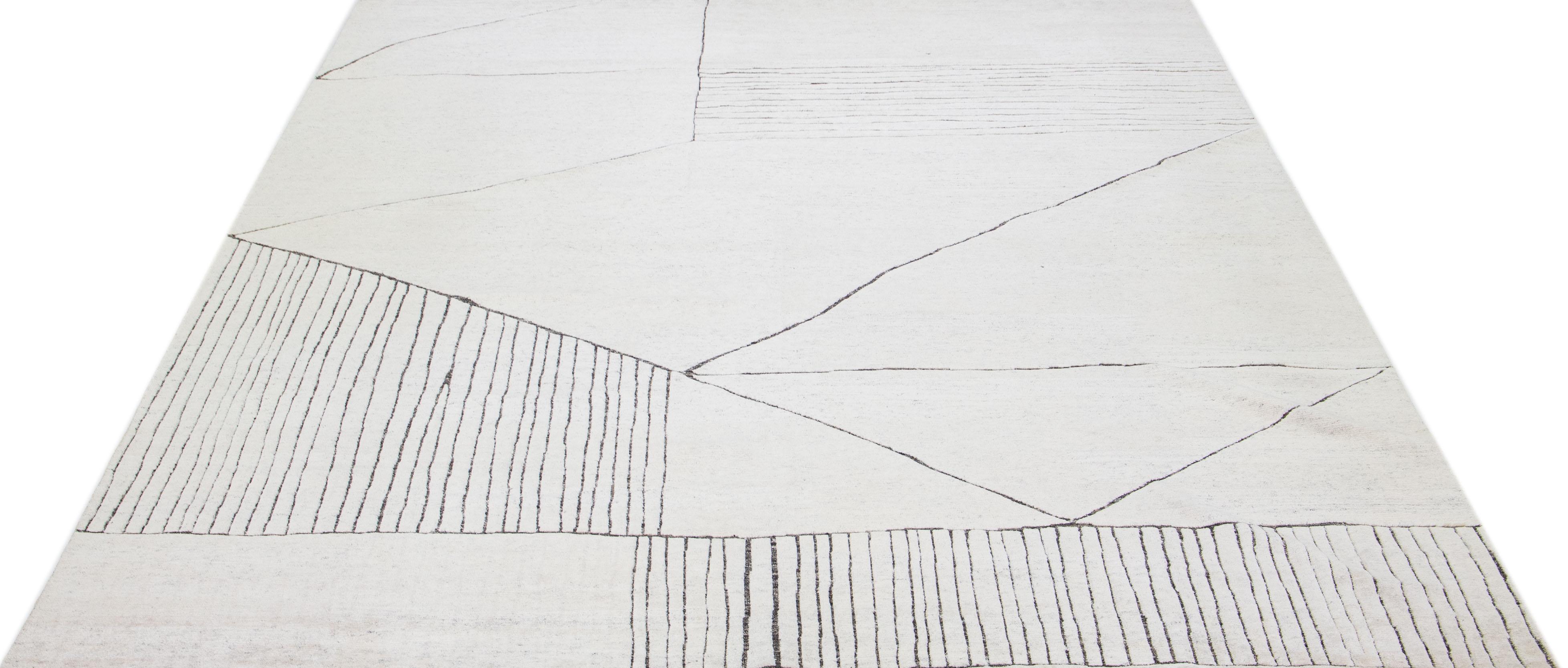 Schöner moderner, handgeknüpfter Wollteppich im marokkanischen Stil mit elfenbeinfarbenem Farbfeld. Dieser Teppich gehört zu unserer Apadana's Safi Collection und zeichnet sich durch ein minimalistisches Design in Grau aus.

Dieser Teppich misst: