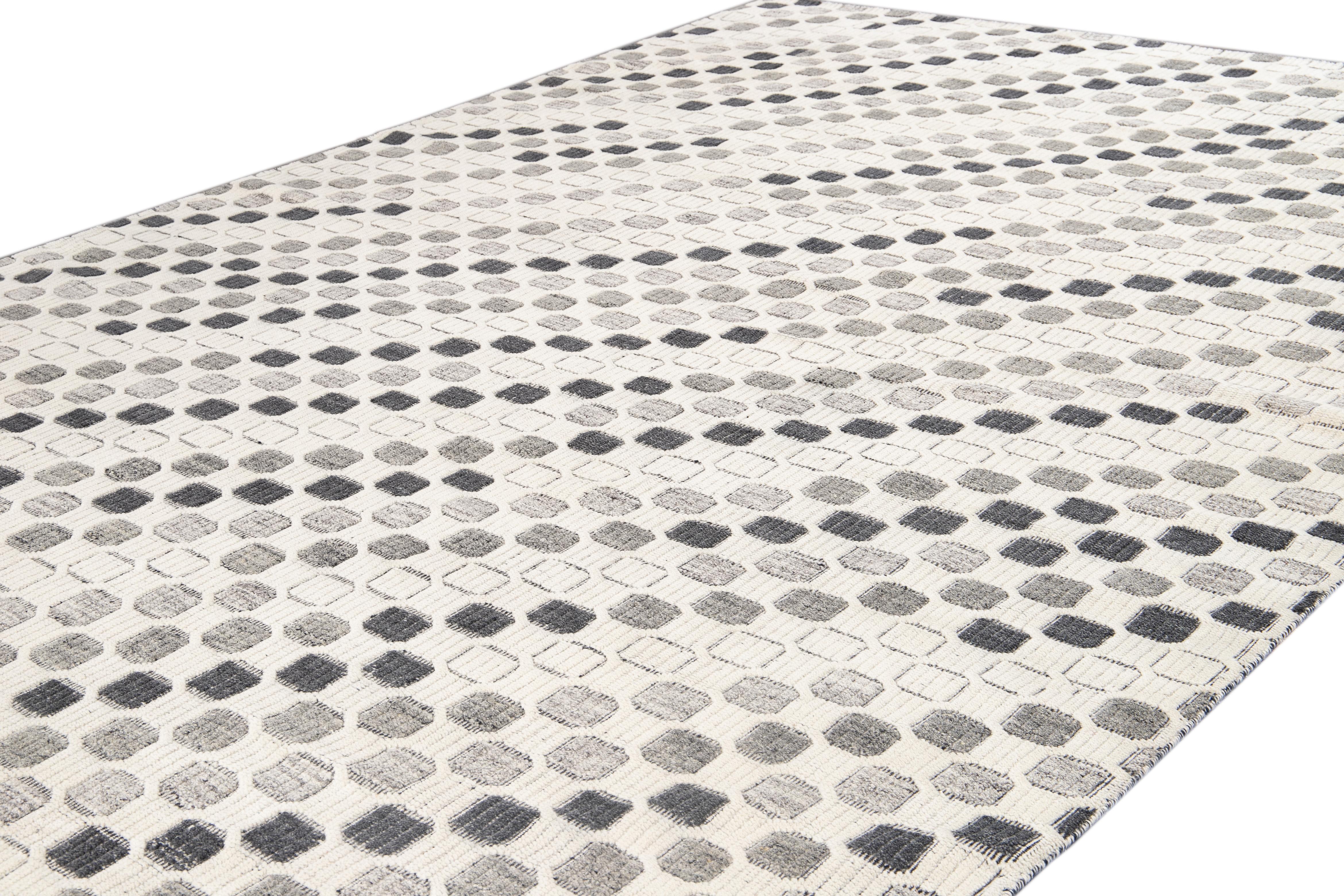 Beautiful modern high-low textured Indian hand-knotted wool rug with an ivory color field. This piece has an all-over geometric pattern design in gray and black accents.

This rug measures 10' 0