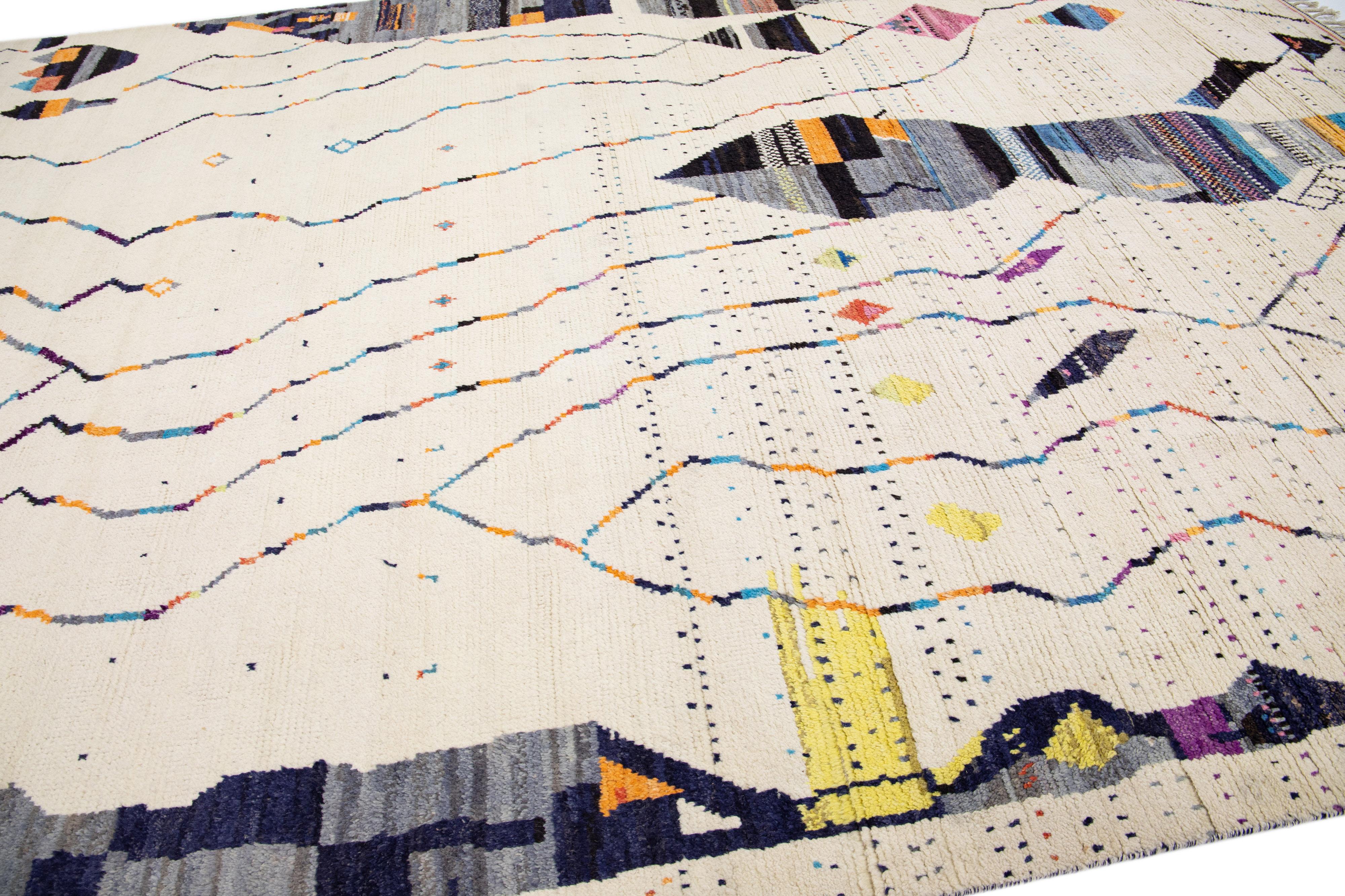 Bellissimo tappeto in lana annodato a mano in stile berbero marocchino con campo avorio. Questo pezzo presenta accenti multicolore in un disegno geometrico astratto all-over.

Questo tappeto misura: 10' x 14' 3
