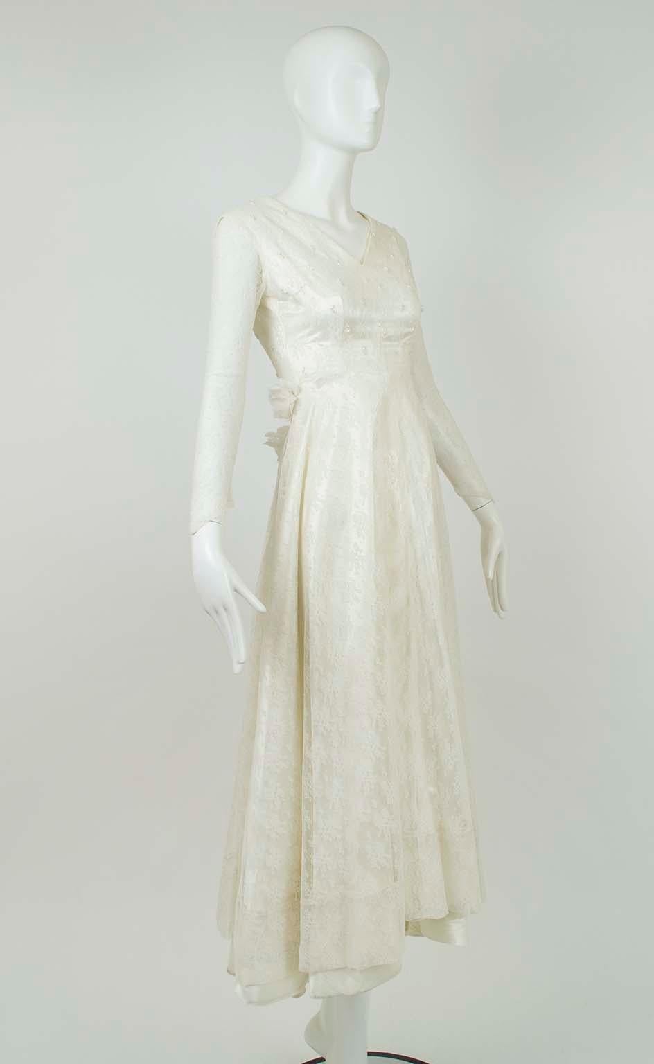 With Taylor’s neck and waistline, Hepburn’s sleeves and Kelly’s lace, this wedding gown has all the requisites of a 1950s heirloom.  We love how the uneven, graduated hemline and derrière-flattering roses cast a modern influence on the otherwise