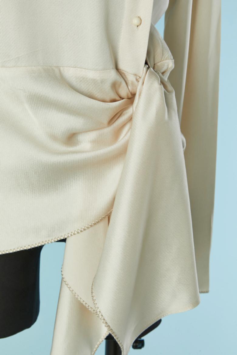Camicetta in rayon avorio con abbottonatura asimmetrica. Chiusura con bottone e asola sul lato sinistro. Fiocco laterale in vita. 
TAGLIA 38 (Fr) M 