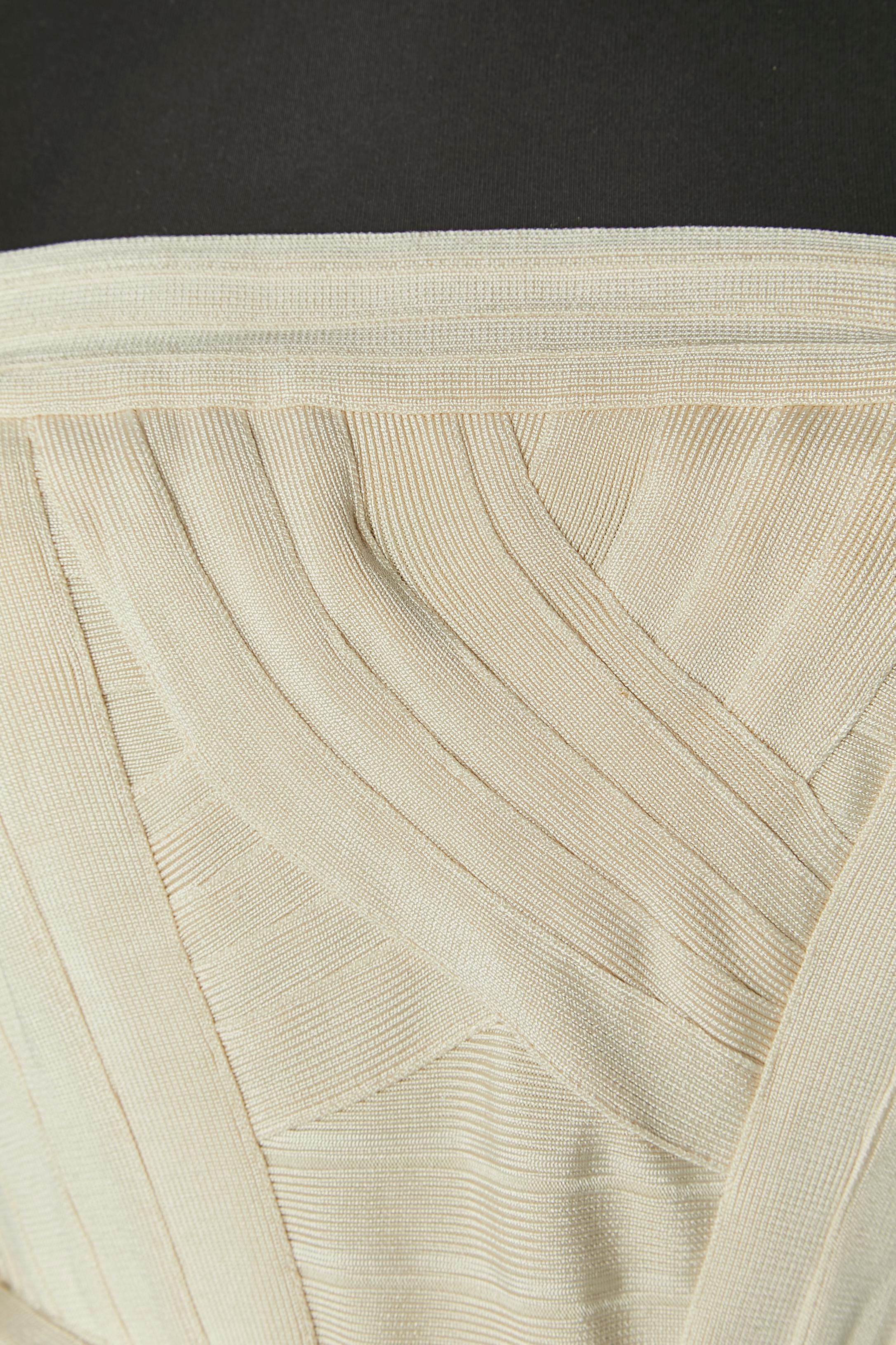 Abito bustier in jersey di rayon avorio con cintura. Composizione della Fabrice: 90% rayon, 9% nylon, 1% elastan. 
Zip invisibile al centro della schiena + chiusura con gancio. Cinturino in silicone sul bordo del bustier all'interno. Chiusura a