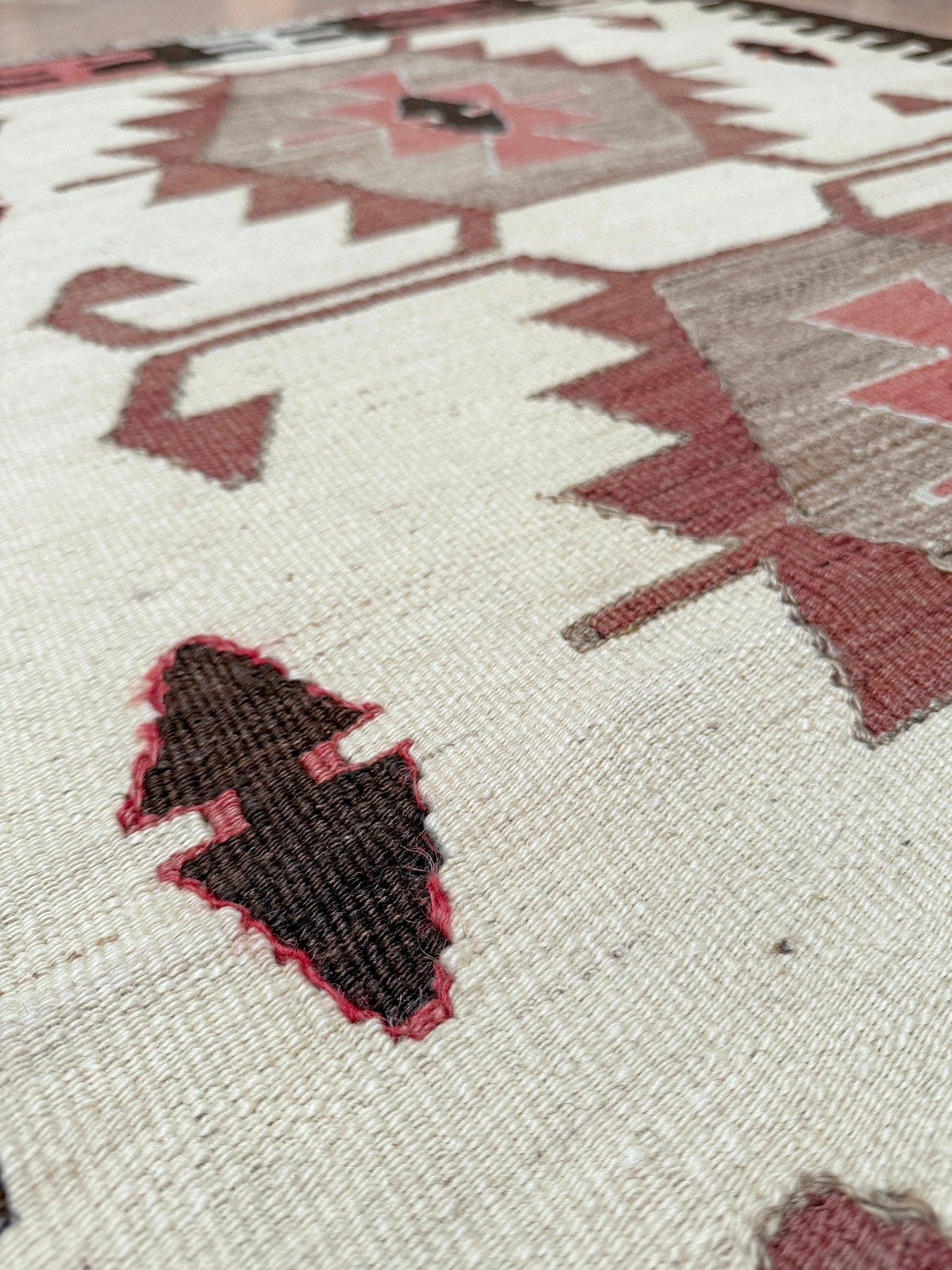 Dieser in der südtürkischen Mut-Region handgewebte Kelim aus der Mitte des Jahrhunderts zeigt ein kühnes, von den Navajos inspiriertes Layout aus gestapelten geometrischen Medaillons, die von gestuften Elfenbeinbändern eingerahmt werden. Die Palette