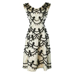Ivory satin cocktail dress with black passementerie embellishment Circa 1950