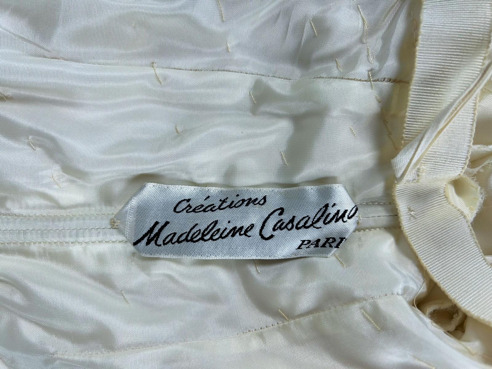 Circa 1970
France

Evening or formal dress in ivory chiffon and silk crepe by Madeleine Casalino in Paris. Glamorous dress, large plunging neckline with bare back, whalebone bustier with heart-shaped pleated cover and crossed over the bust. Skirt