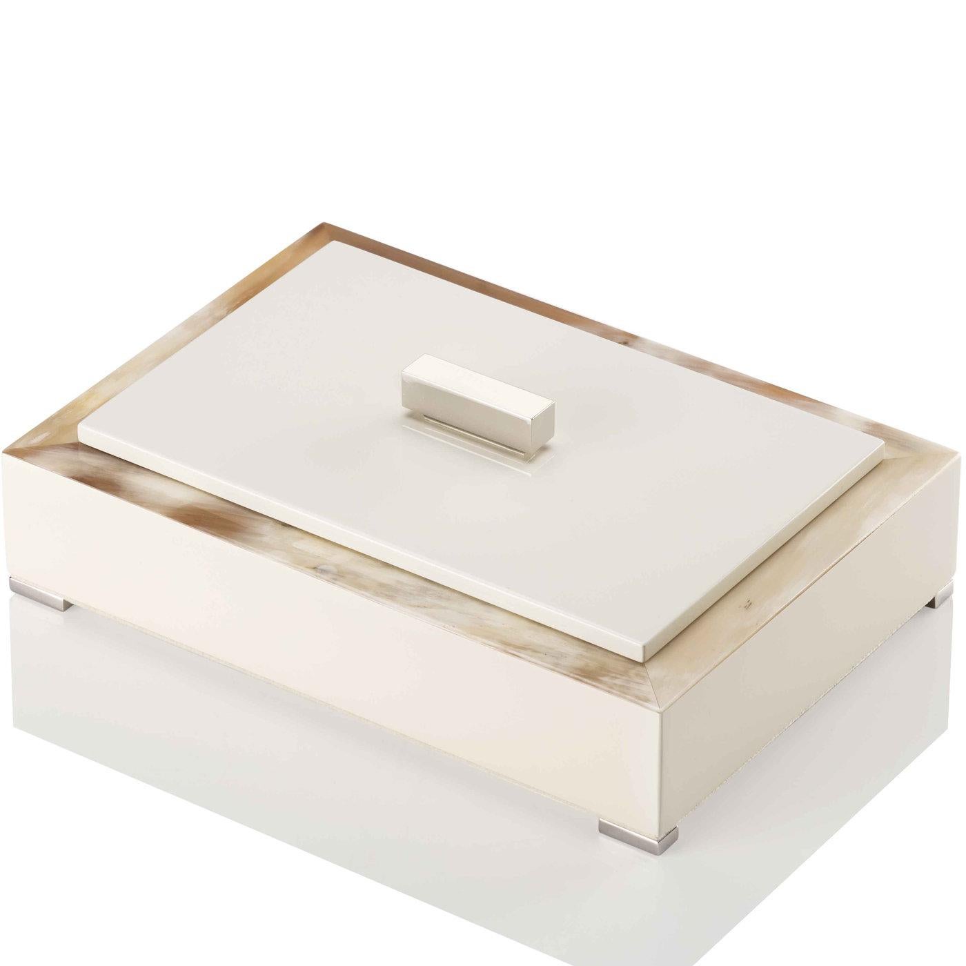 Exuding a lavish flair intertwined with its geometrical design, this refined ivory storage box showcases a precious structure in horn and wood and a rectangular lid in the same lacquered, glossy finish with a chromed brass handle. The interior is