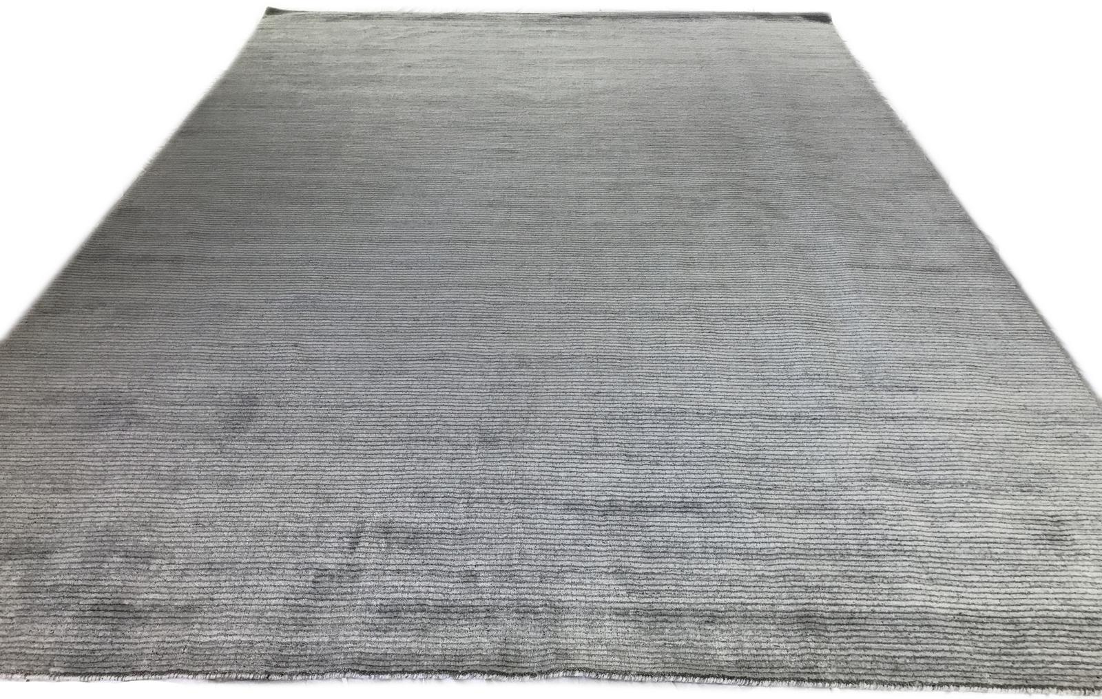 Light and dark alternate to given vibrancy to this contemporary Indian wool area rug. Ivory and gray. Hand knotted in India.