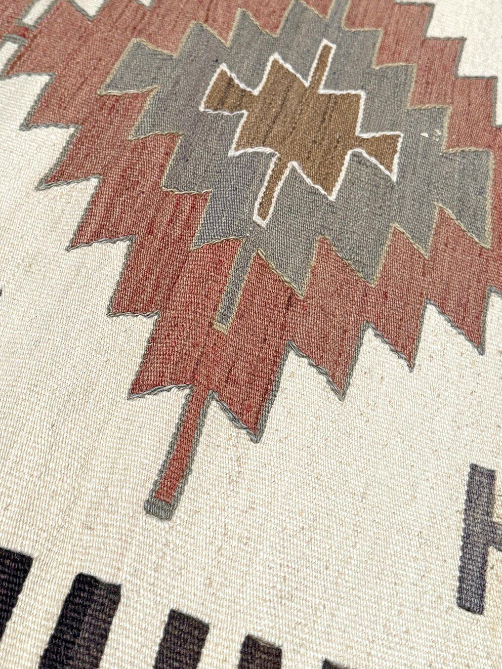 Tissé à la main dans la région de Mut, dans le sud de la Turquie, ce kilim du milieu du siècle capture la précision géométrique et l'harmonie terreuse qui définissent le tissage anatolien. Avec ses trois médaillons superposés aux formes de diamant