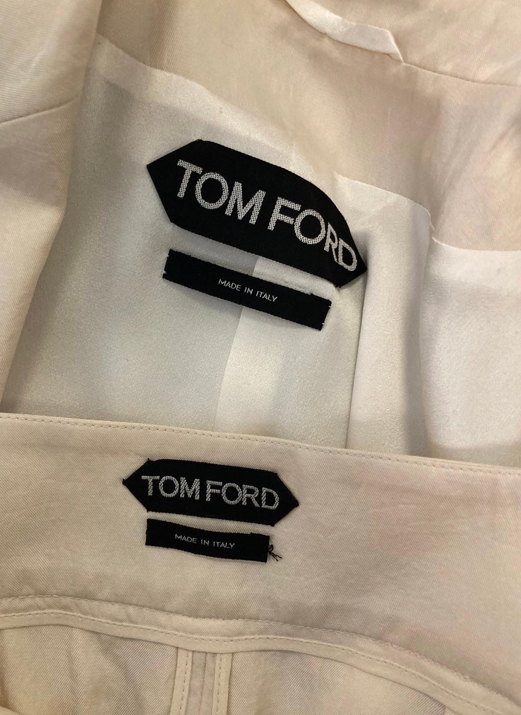 Tailleur jupe ivoire Tom Ford de la marque éponyme. Veste ivoire soyeuse de style blazer et jupe crayon assortie sous le genou. La jupe crayon est dotée d'une fermeture à glissière en métal gunmetal sur le devant, qui se referme à mi-chemin pour