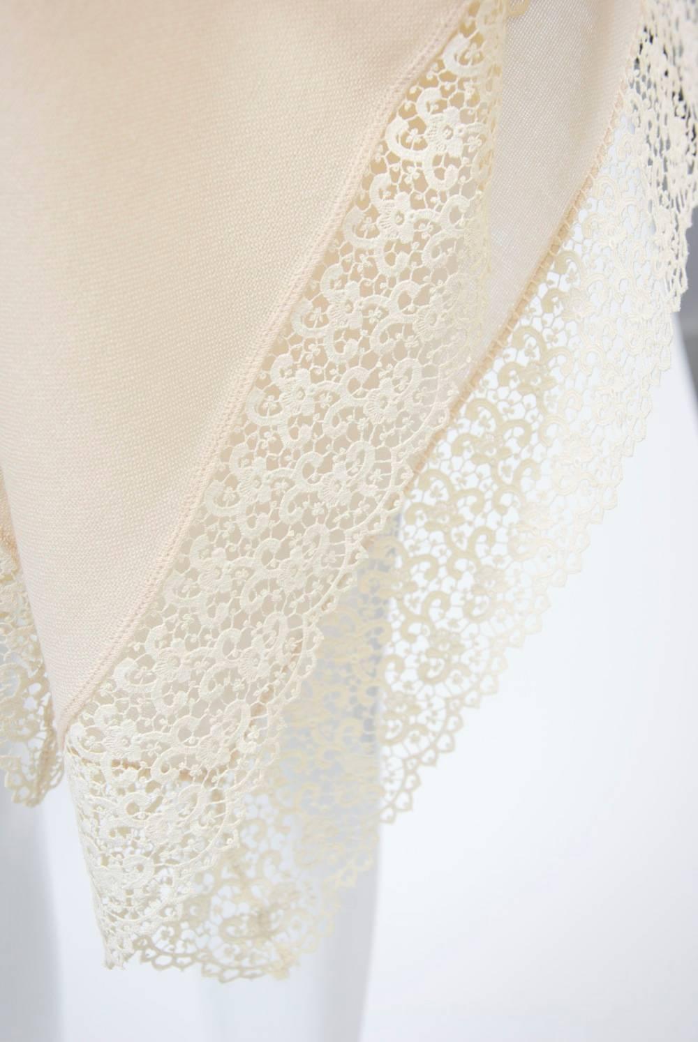 A finely woven shawl in ivory wool bordered with lace. Large square in excellent condition. Beautiful, lightweight hand. Bergdorf Goodman label.
