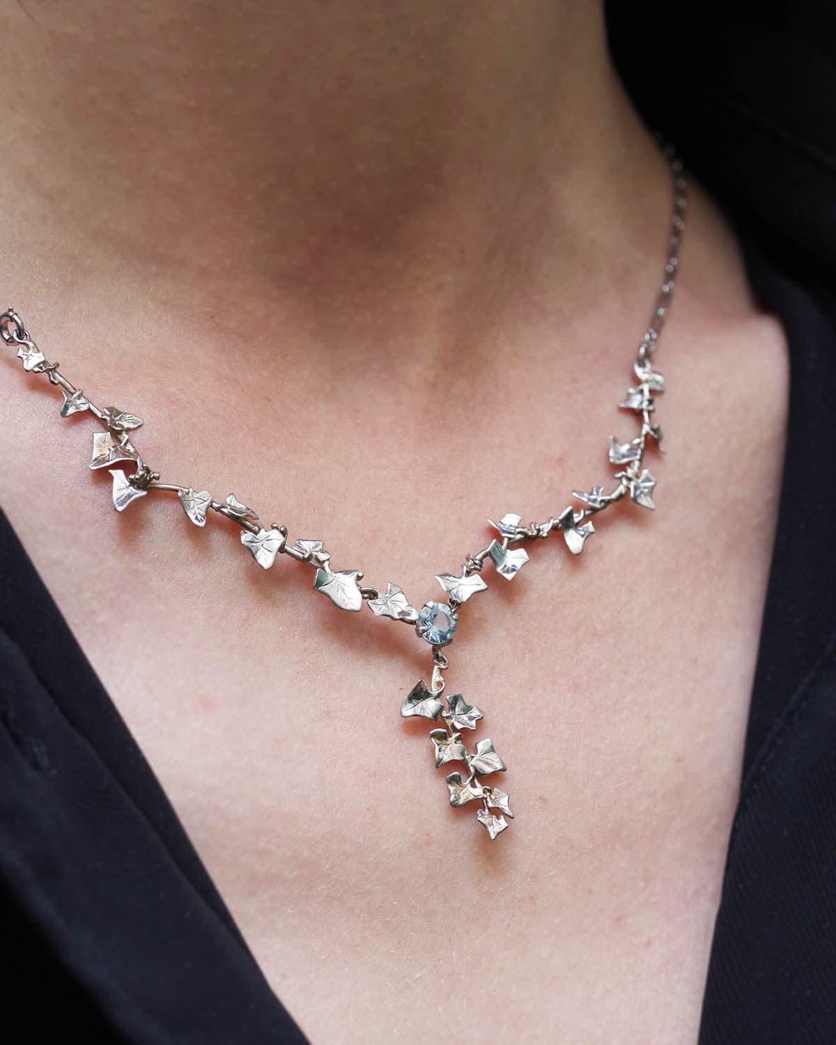 Art Nouveau Aquamarine ivy necklace in platinum and 18 karat white gold. Necklace from the Art Nouveau period, composed of a platinum chain with a double lobster clasp, holding a pendant formed of three rigid ivy branches that rest on the upper