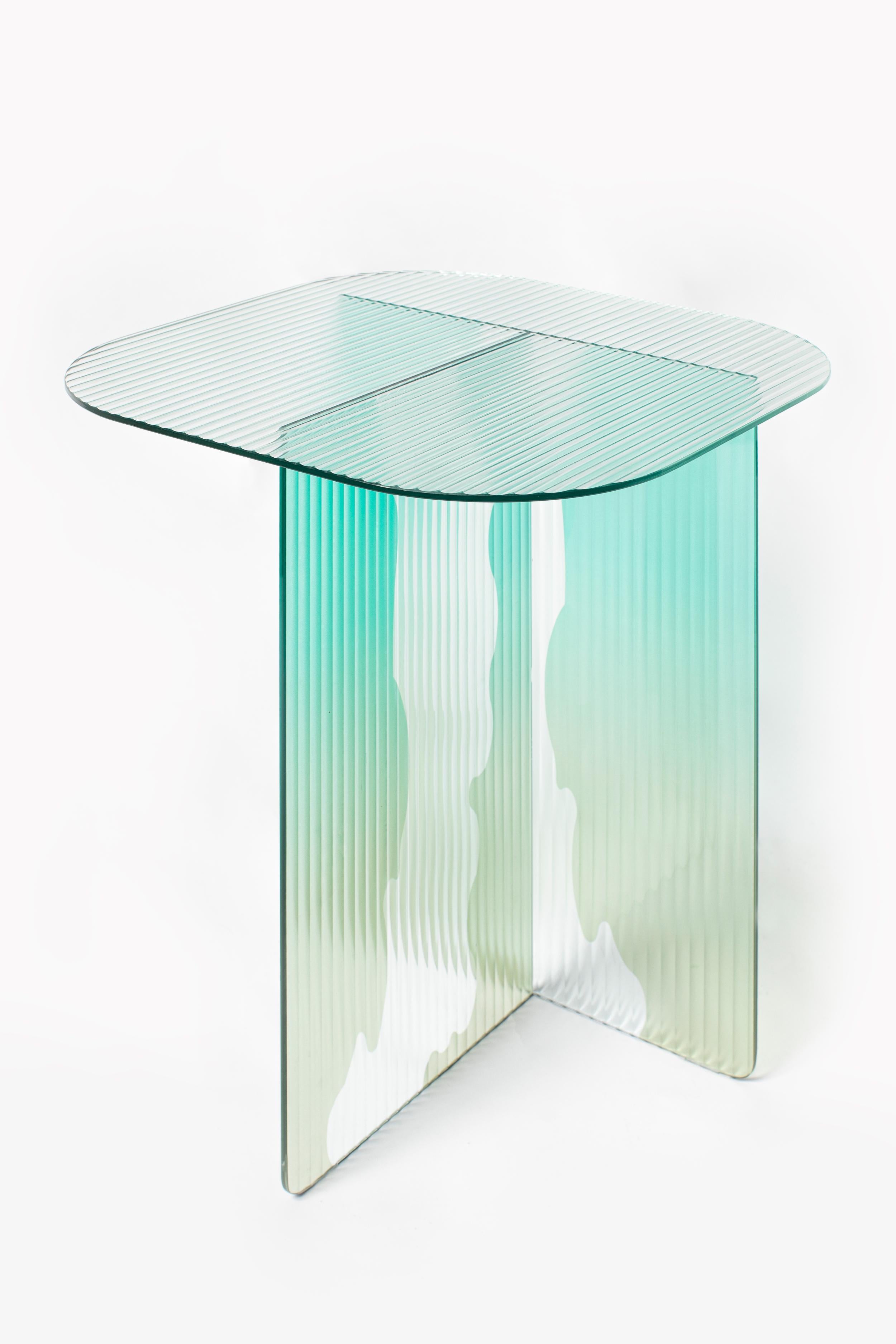Ivy I Side Table by Yugen Lab
Dimensions: D 50 x W 50 x H 54 cm.
Materials: 6mm tempered ribbed glass and flat tempered glass.

Ivy-I is a vibrant glass side table with a coastal color palette, exuding tranquility. Its tree bark-patterned legs and