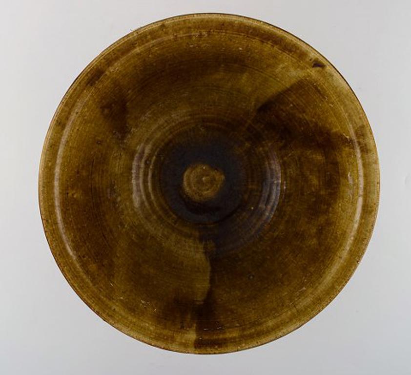 Ivy Lysdal, b. 1937. Danish ceramist and painter.
Large unique bowl with uranium glaze. 1970s.
In very good condition.
Measures: 31 x 13 cm
Signed.

Educated at the Arts & Craft school in Copenhagen (1954-1957).
Employed at Kähler