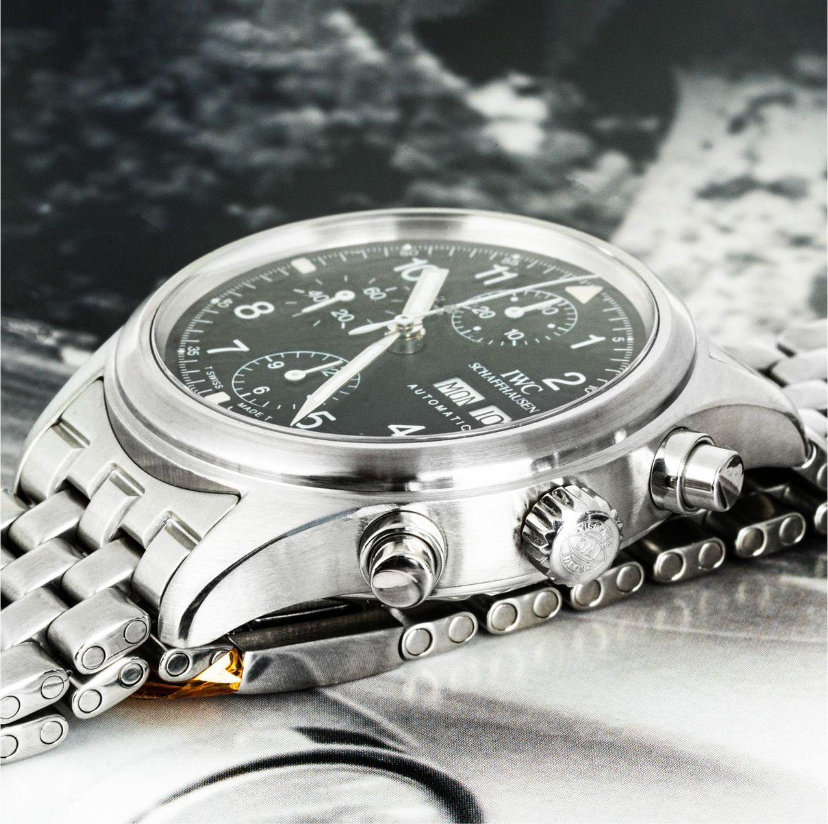 A stainless steel Flieger Chronograph wristwatch by IWC. Featuring a black dial with arabic numbers, a date aperture, a day indication, 3 chronograph counters and a steel bezel. Fitted with a sapphire glass and powered by a self-winding automatic