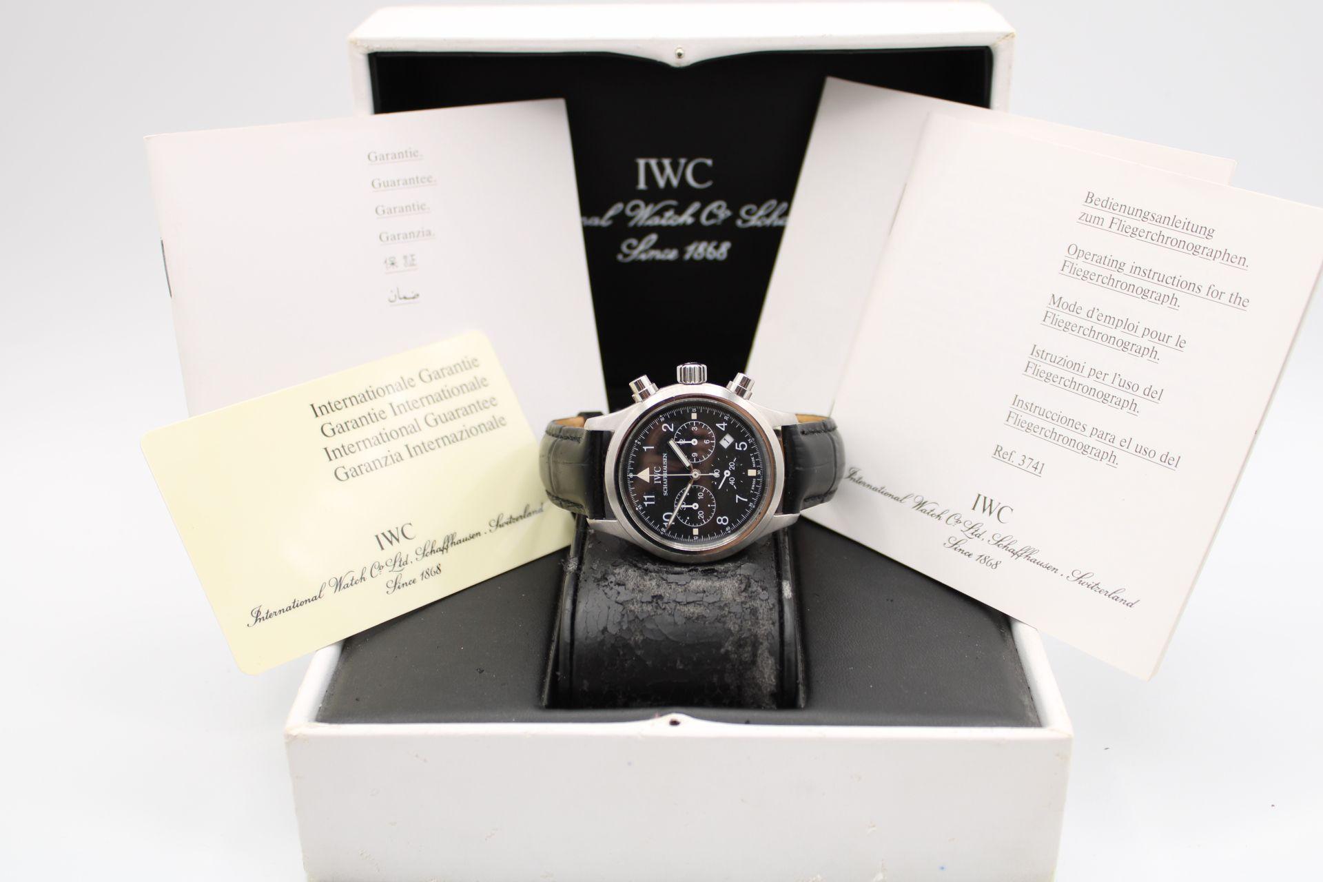 This IWC Pilot is accompanied by its inner box, manuals and warranty card dated 1997. 

The IWC Pilot Chronograph, model IW3741, features a 36mm stainless steel case, black dial with Arabic numerals, three sub-dials positioned at 3, 6 and 9 o'clock,
