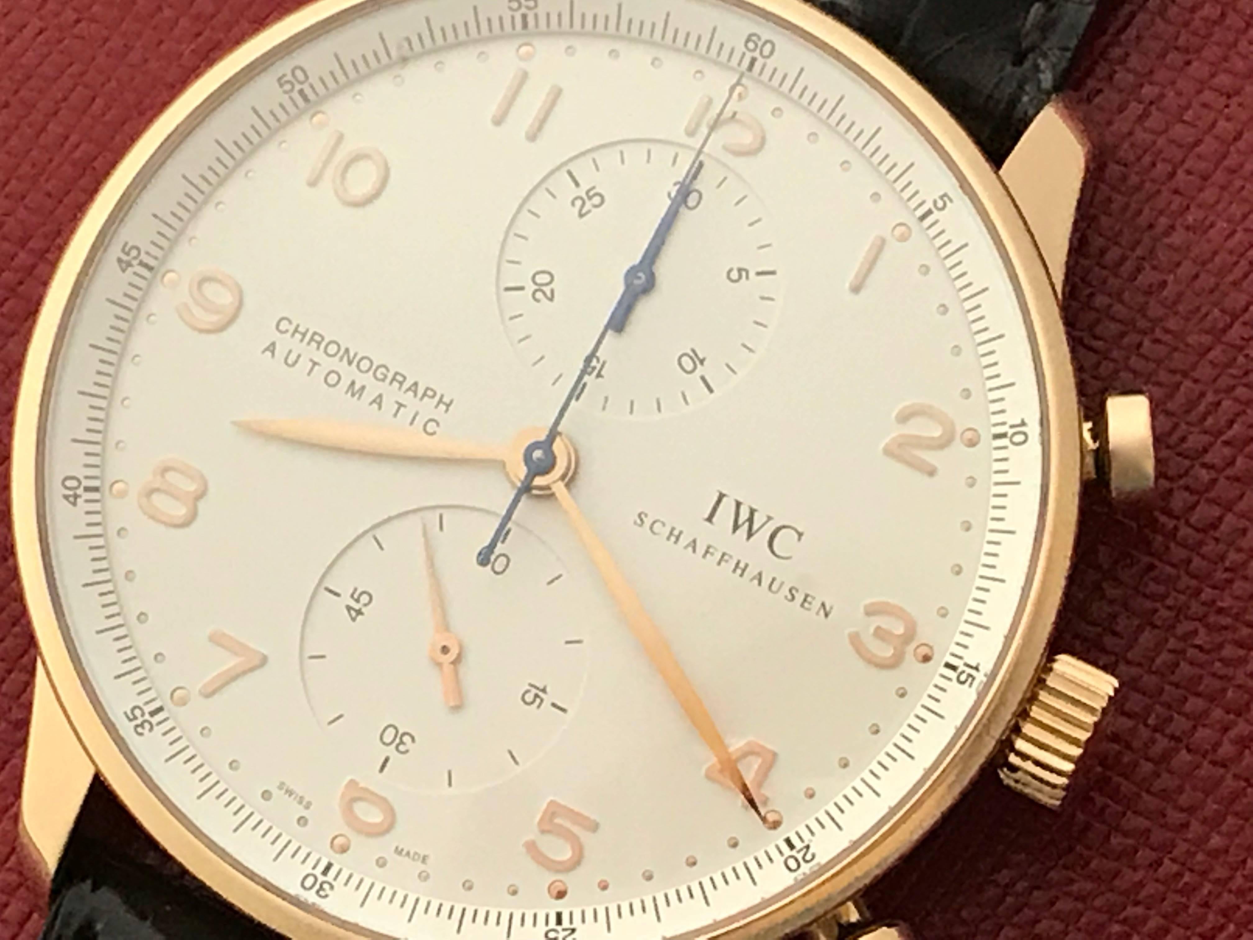 Mens IWC Portuguese Automatic wrist watch. Model 3714-002. Certified pre-owned and ready to ship. Silvered Dial with rose gold Arabic numerals, and 18k rose gold round case with exposition back to view movement. (42mm). Dark brown Alligator strap