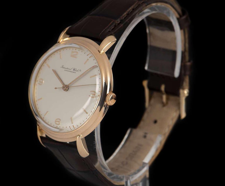A 37 mm 18k Rose Gold Vintage Men's Wristwatch from the 1980s, silver dial with applied arabic numbers 3, 6, 9 and index batons, a fixed 18k rose gold stepped bezel, a brand new brown leather strap (not by IWC) with an original gold plated pin