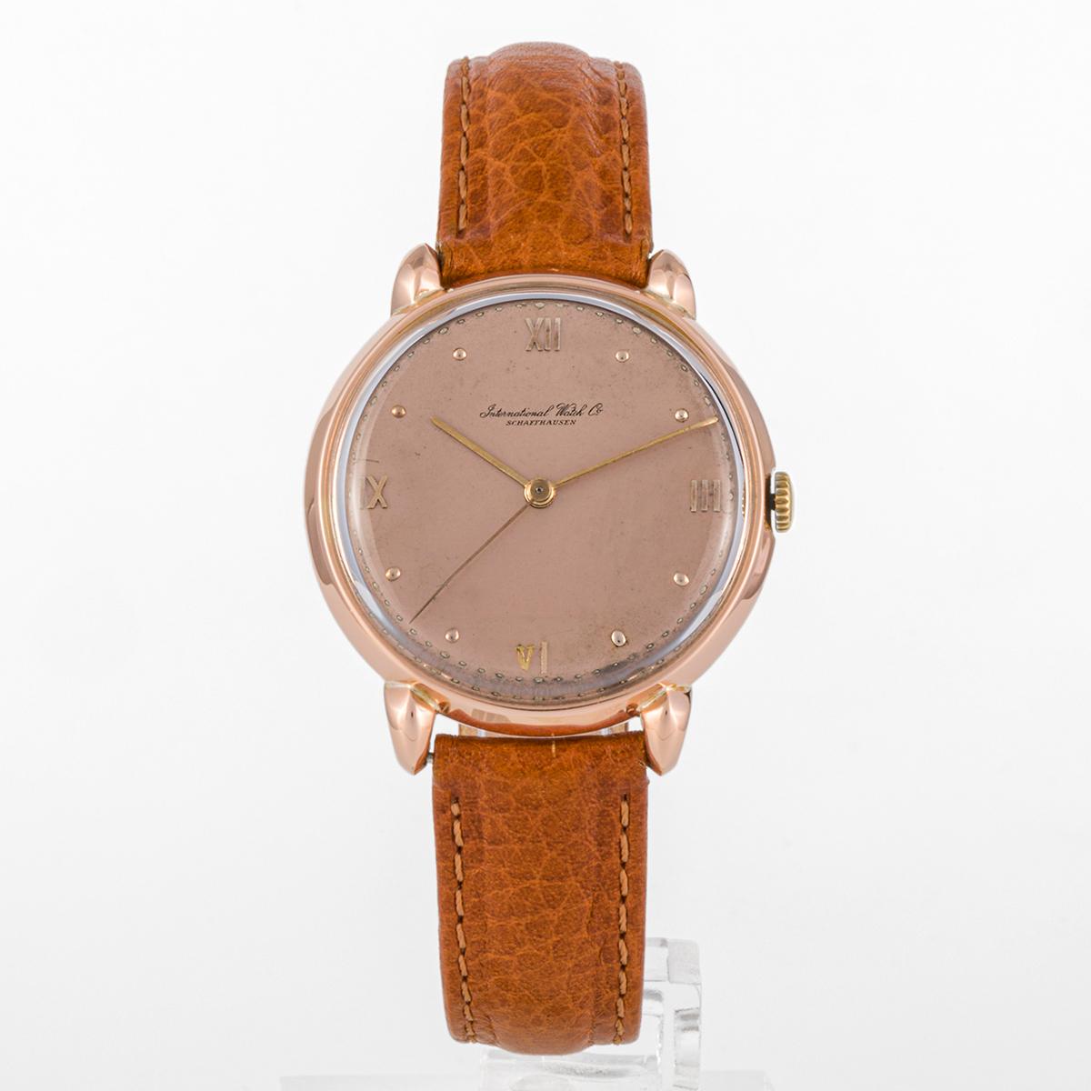 This is a collector piece from 1960s. This IWC for gentleman has a rose gold case and leather bracelet, and an unusual dial with pink color.