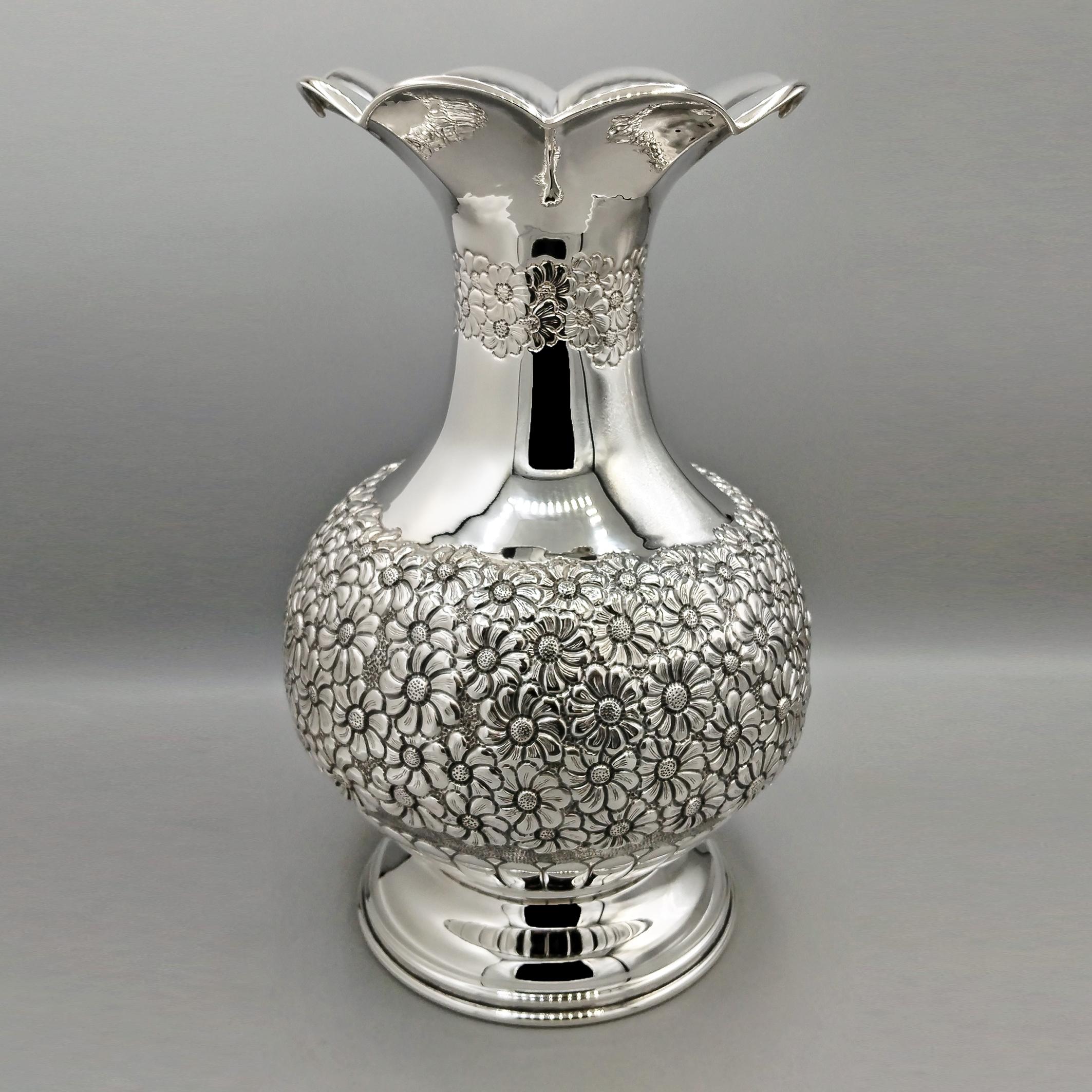 The vase was shaped into a rounded, rounded form and placed on a stepped round base. The central part of the body was embossed with a daisy motif and then chiseled. The upper part of the vase was left plain, except for a chiseled frame that features