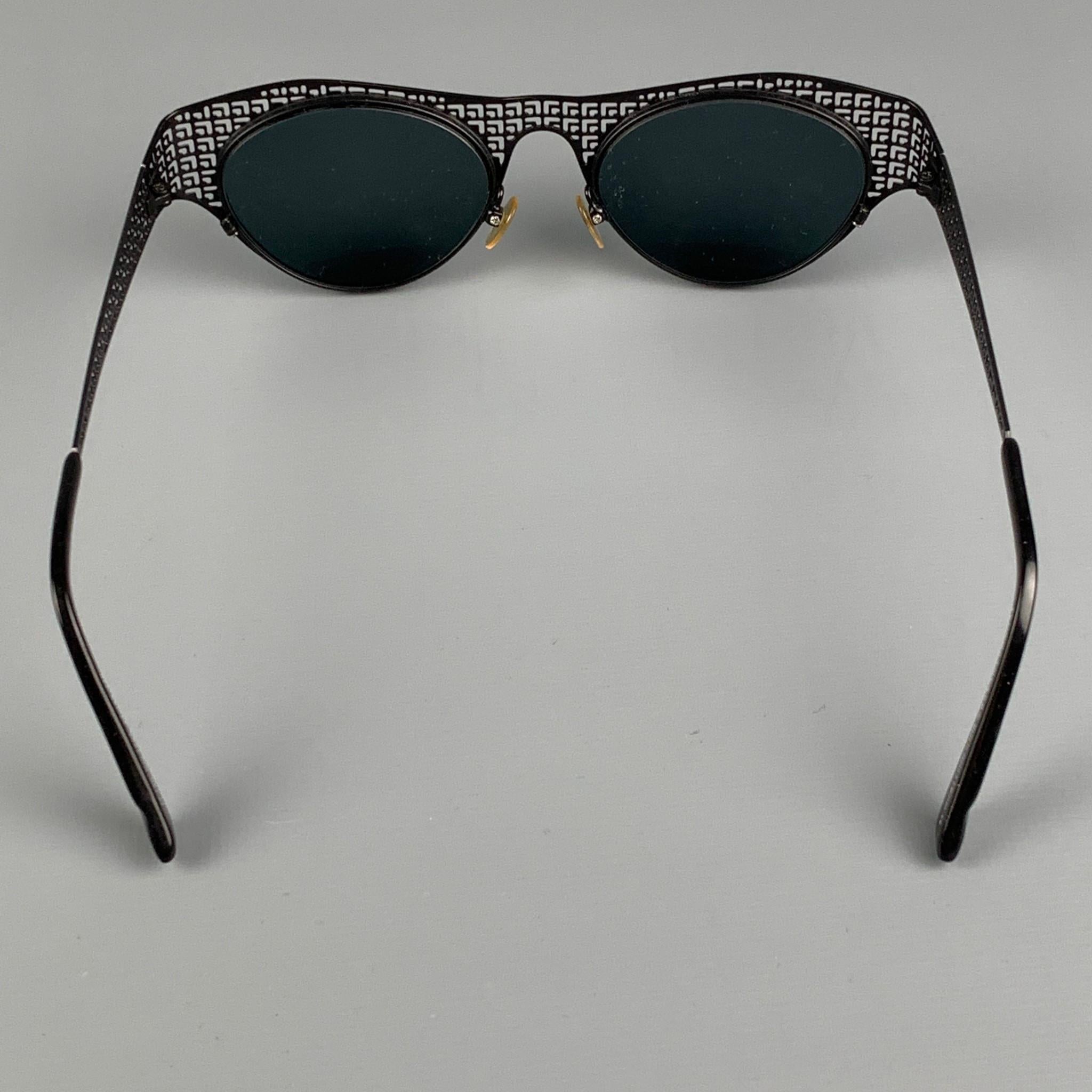 IYOKO-INYAKE sunglasses comes in a black & charcoal madacrylic metal featuring tinted lenses. Includes case. Made in Japan. 

Very Good Pre-Owned Condition.
Marked: 120 Col.140A 49-20 140
Original Retail Price: $320.00

Measurements:

Length: 14