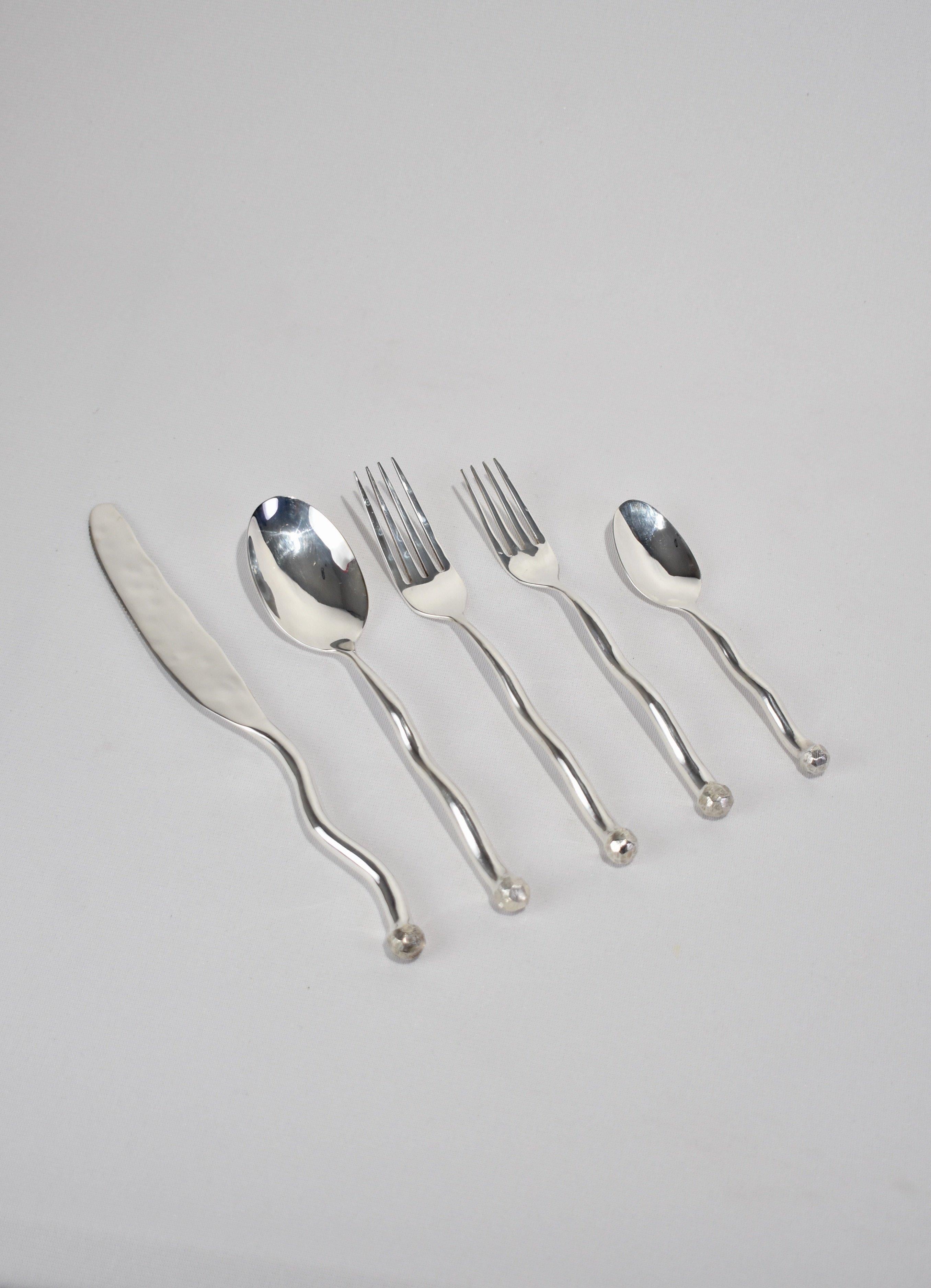 Beautiful, 5 piece silver plated flatware set in 'Sphere' pattern. Each piece features an undulating handle and hammered textured knob on end. Impressed above knob on underside of handle: 'IZABEL LAM'. 

Purchase includes one set of five